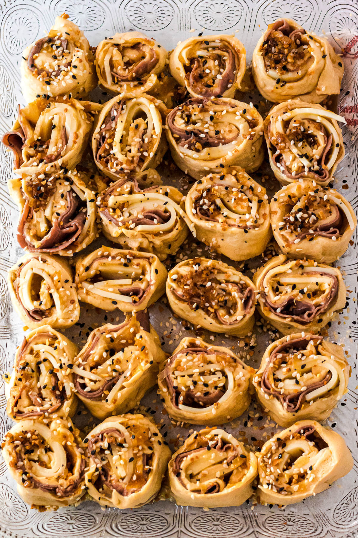 Beef pinwheels arranged in a glass baking dish before they are baked.