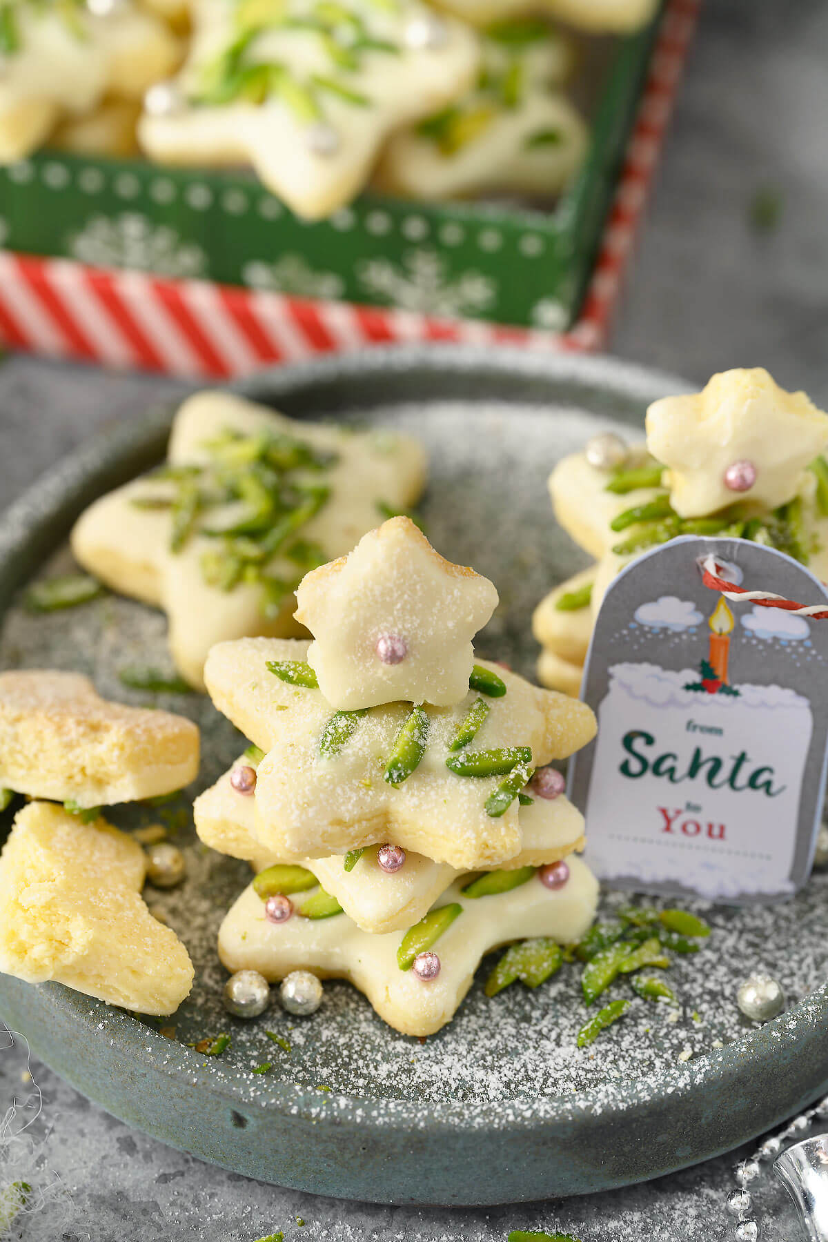 Star Cookies piled up in the shape of a small Christmas tree on a dark grey plate.