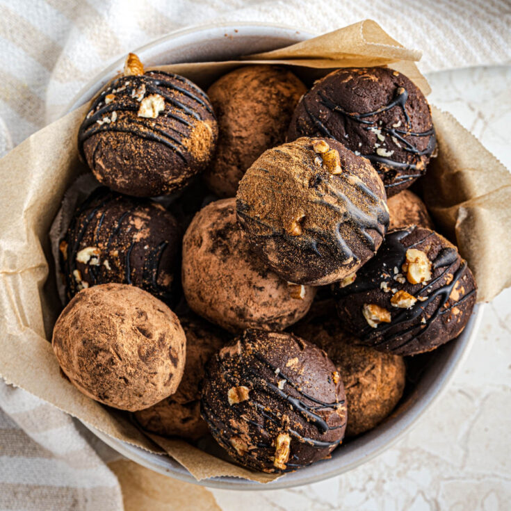 A bowl full of simply decorated dark chocolate avocado truffles.