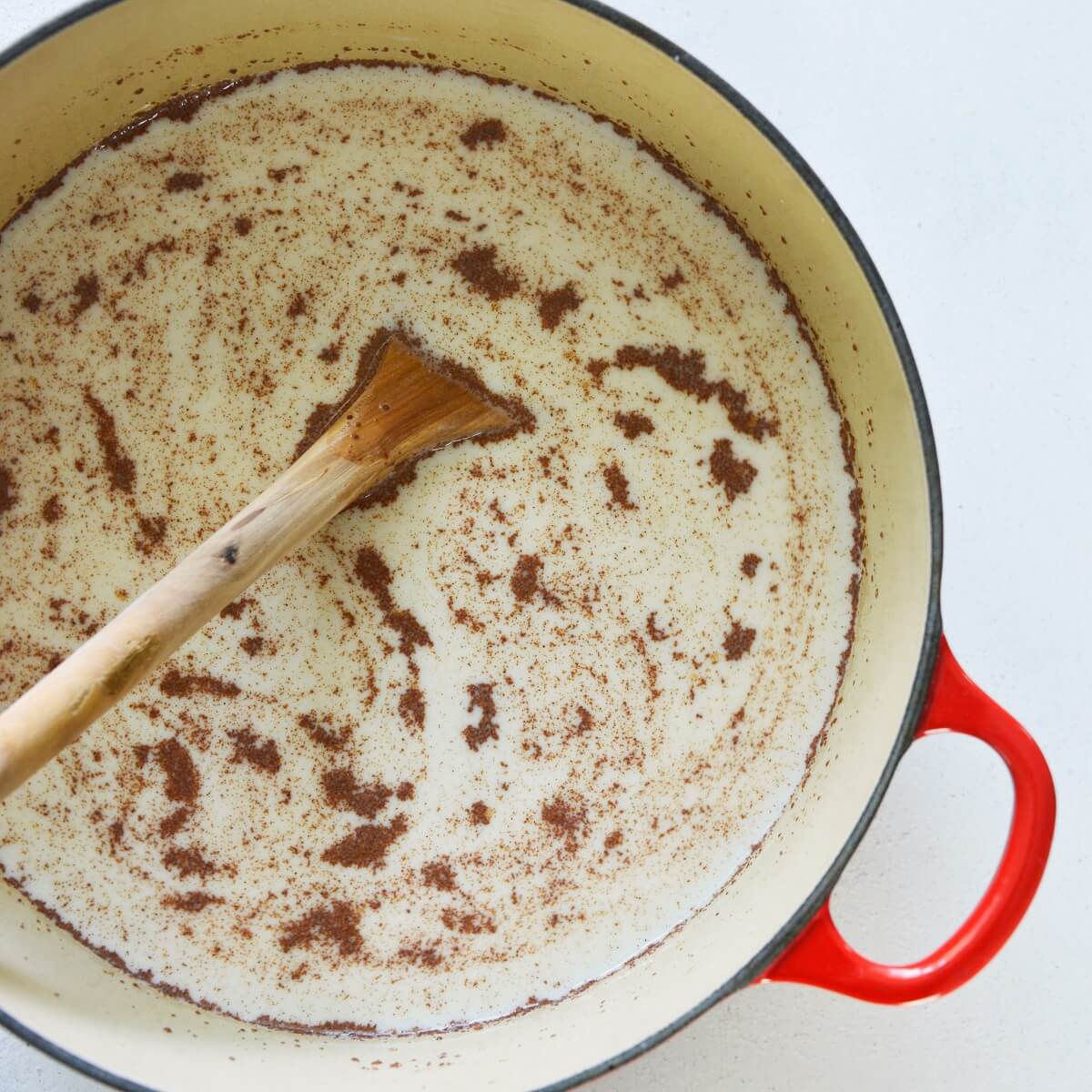 Swirls of ground cinnamon in old fashioned rice pudding.