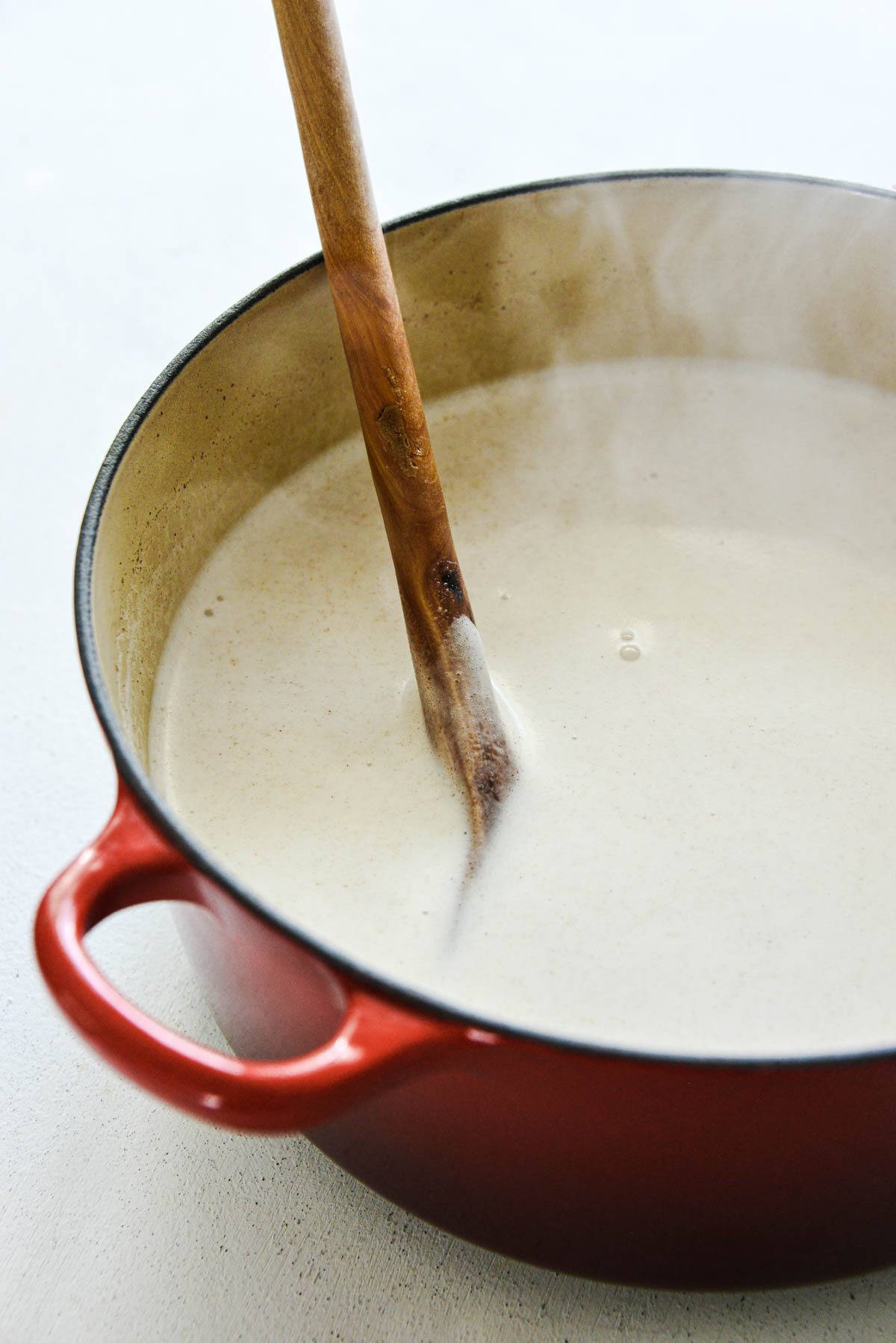 Steaming milk and rice in a red Dutch oven.