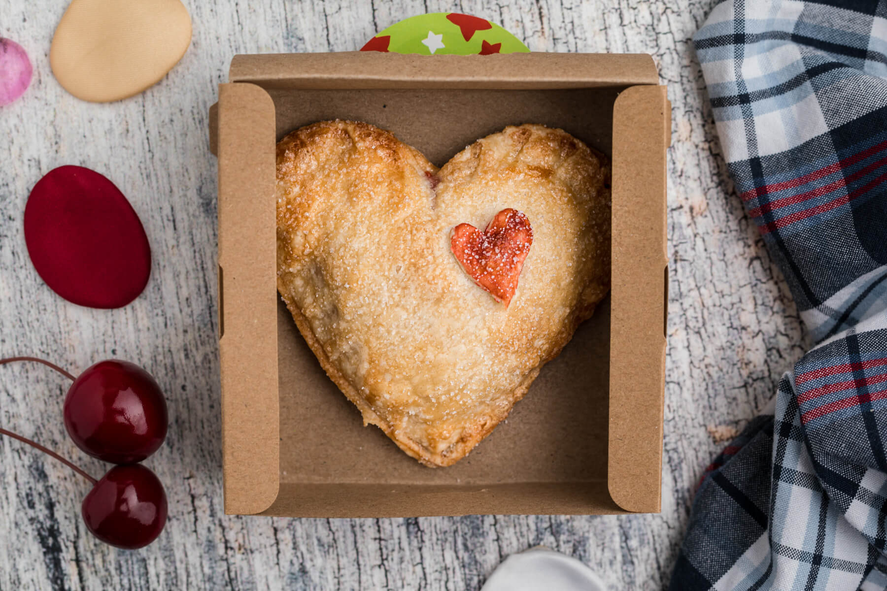 One heart shaped cherry hand pie in a takeaway box.