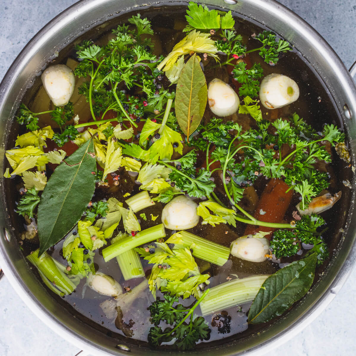 A stock pot filled with beef bones, vegetables and aromatics.