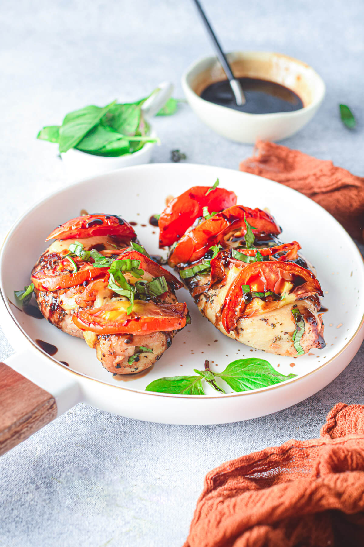 Two chicken caprese stuffed with mozzarella and tomatoes then garnished with fresh basil and balsamic drizzle.