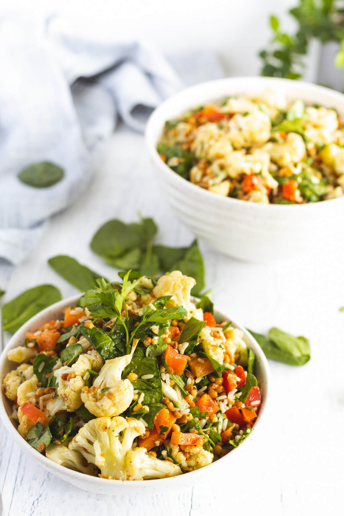 White bowls containing servings of vibrant roasted cauliflower salad.