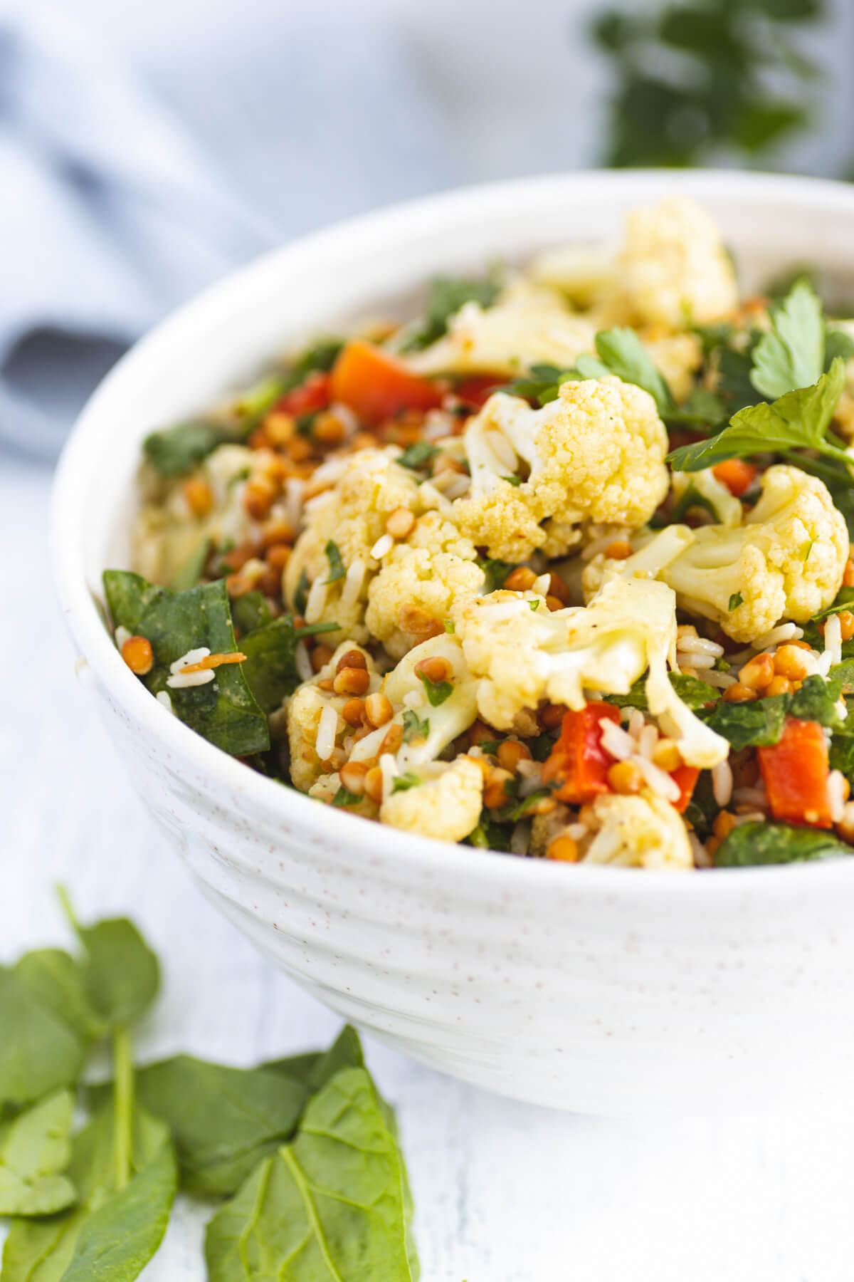 A white bowl filled with colourful roasted cauliflower salad.