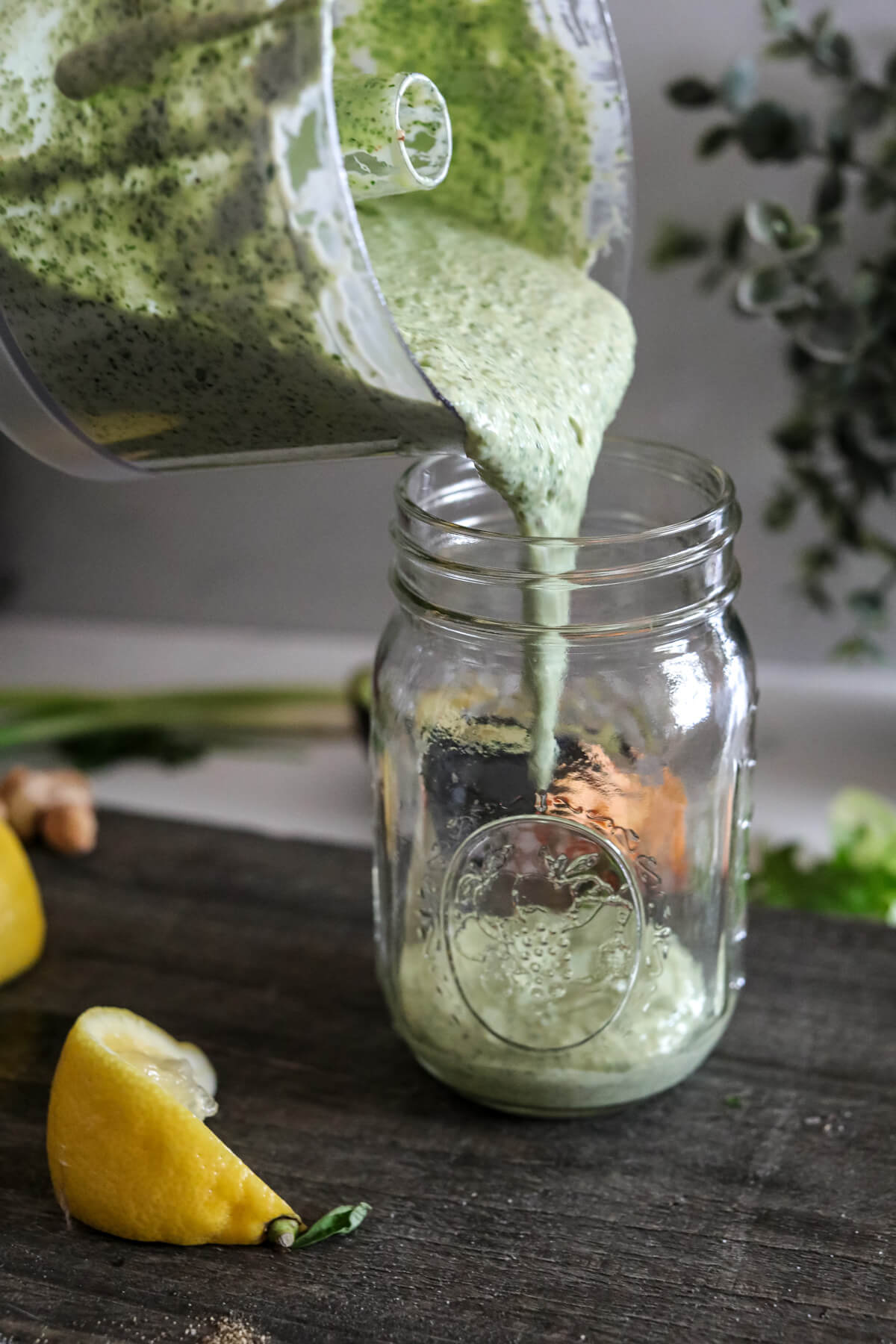 Freshly made Green Goddess Dressing being poured into a glass jar.
