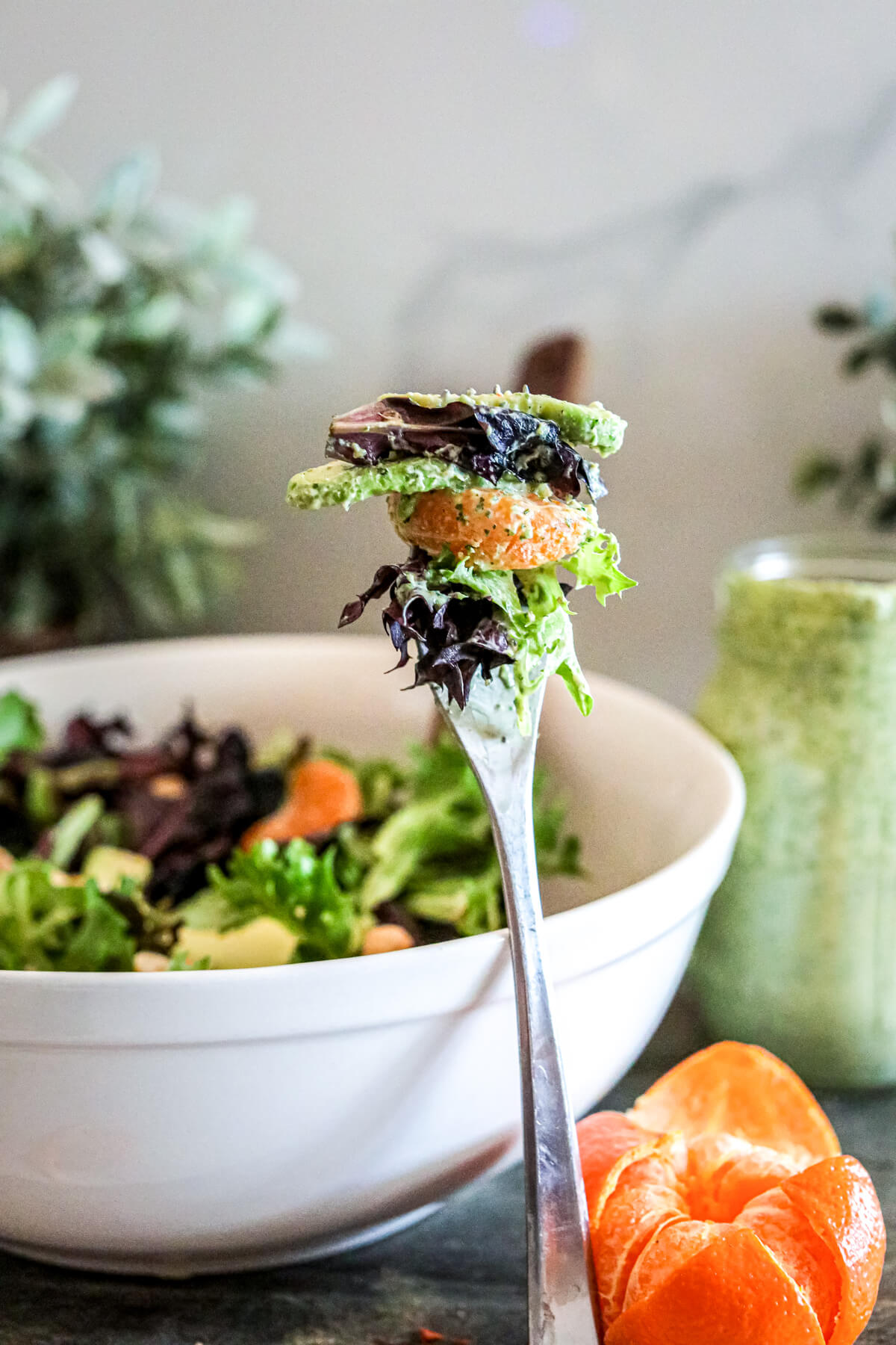 A fork filled with a colourful Spring Mix Salad with Green Goddess Dressing.