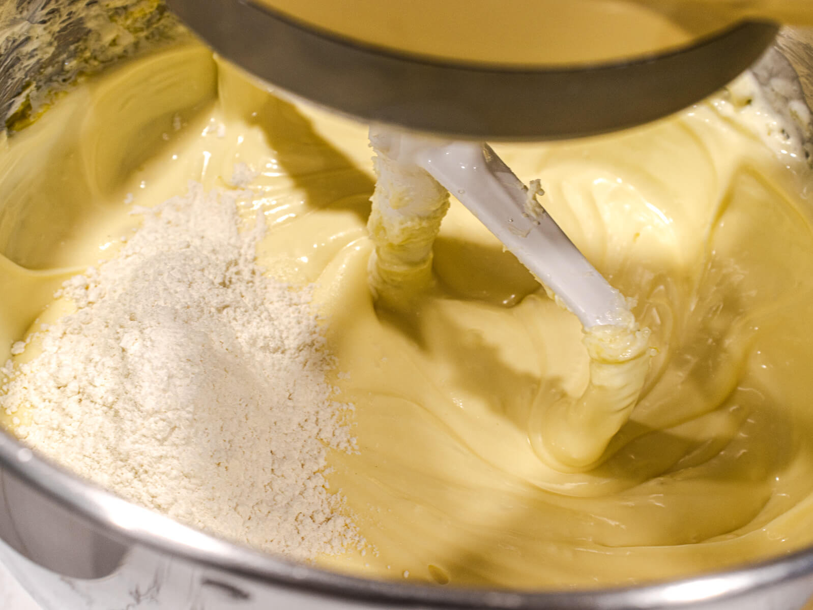 Cheesecake batter being mixed in a stand mixer.
