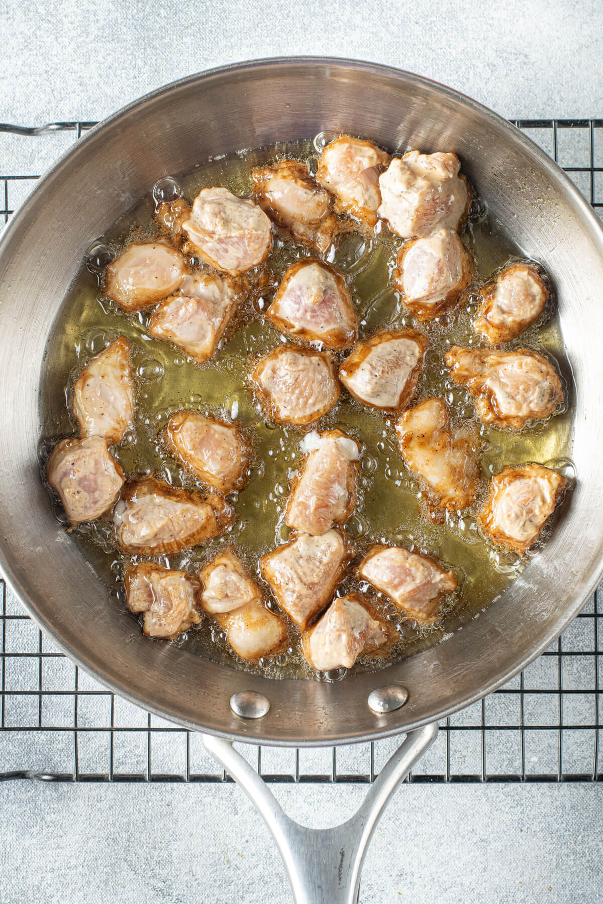 Stir frying chicken in a frying pan.