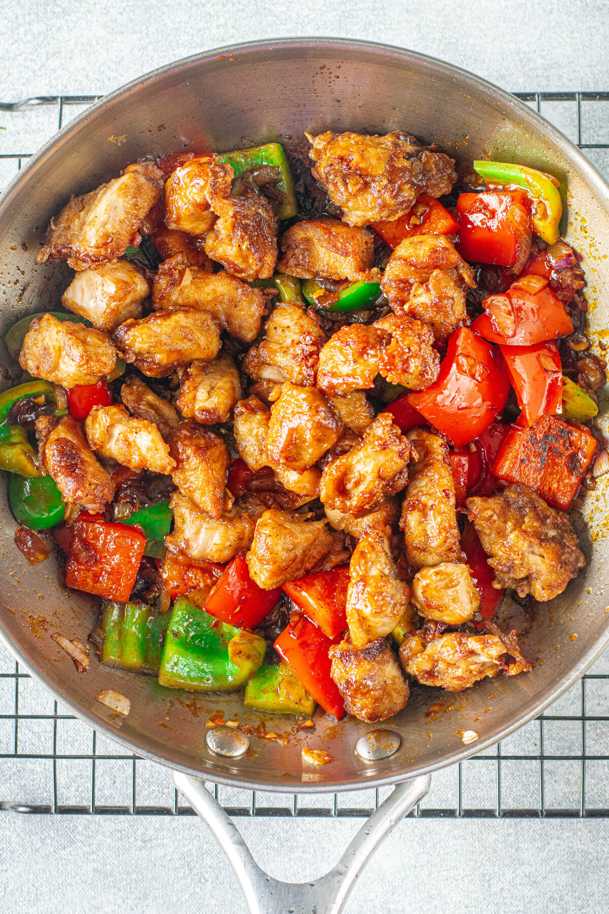 Stir fried chicken and vegetables in a frying pan.