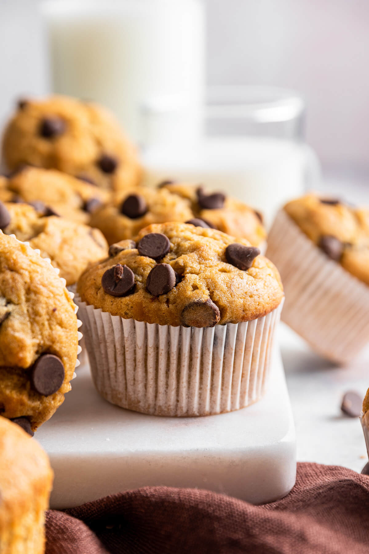 Golden baked Tahini Chocolate Chip Banana Muffins in white muffin papers.