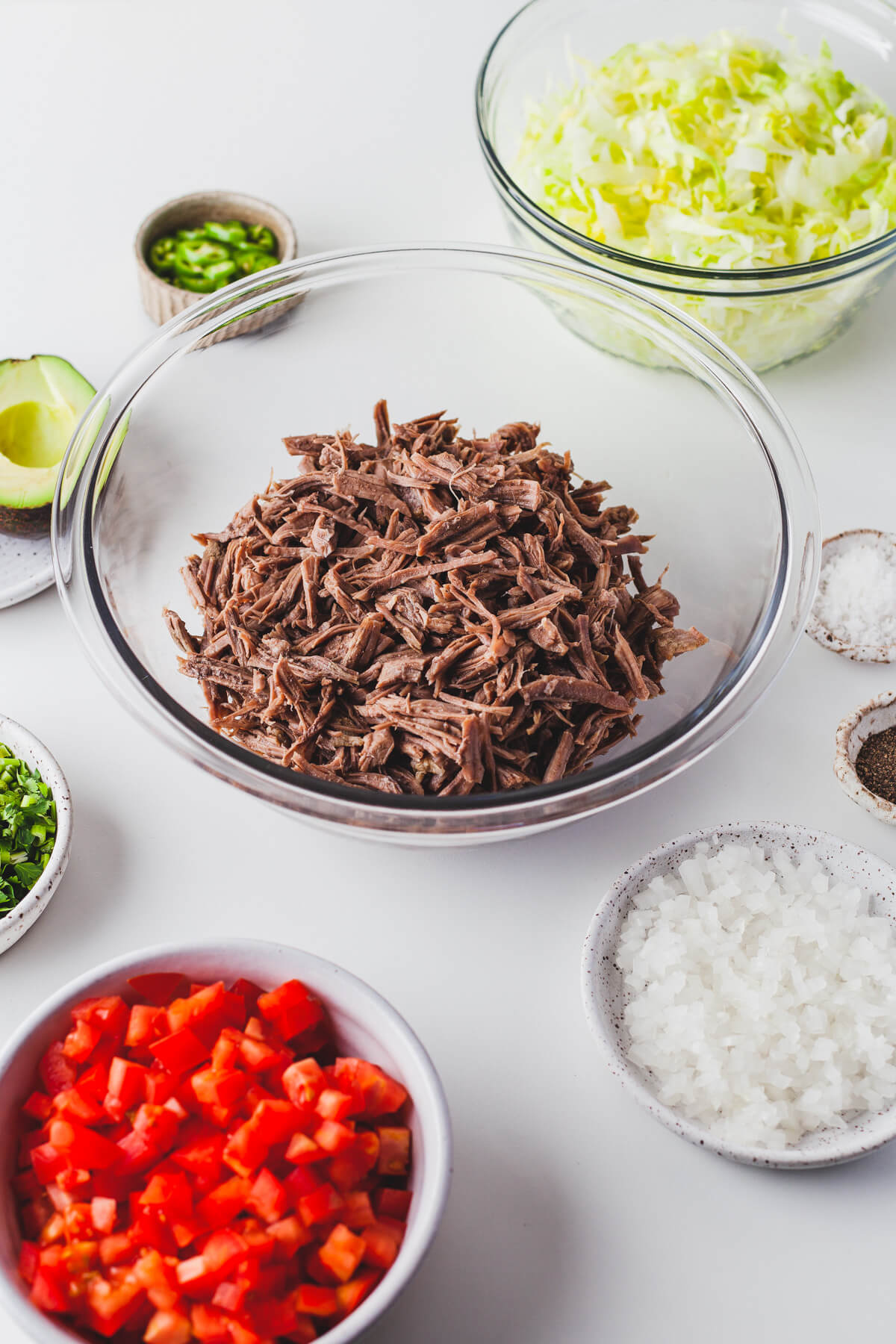 Shredded beef in a clear glass bowl.