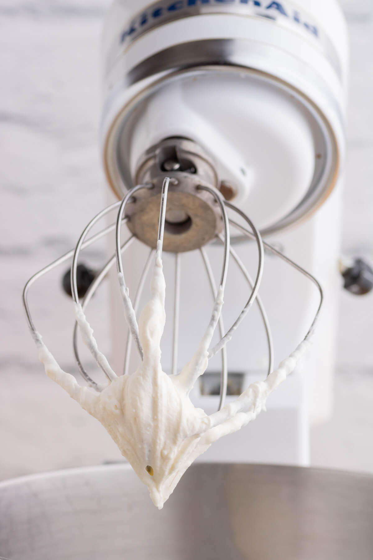 Whipped Mascarpone cream on the beater of a Kitchen Aid stand mixer.
