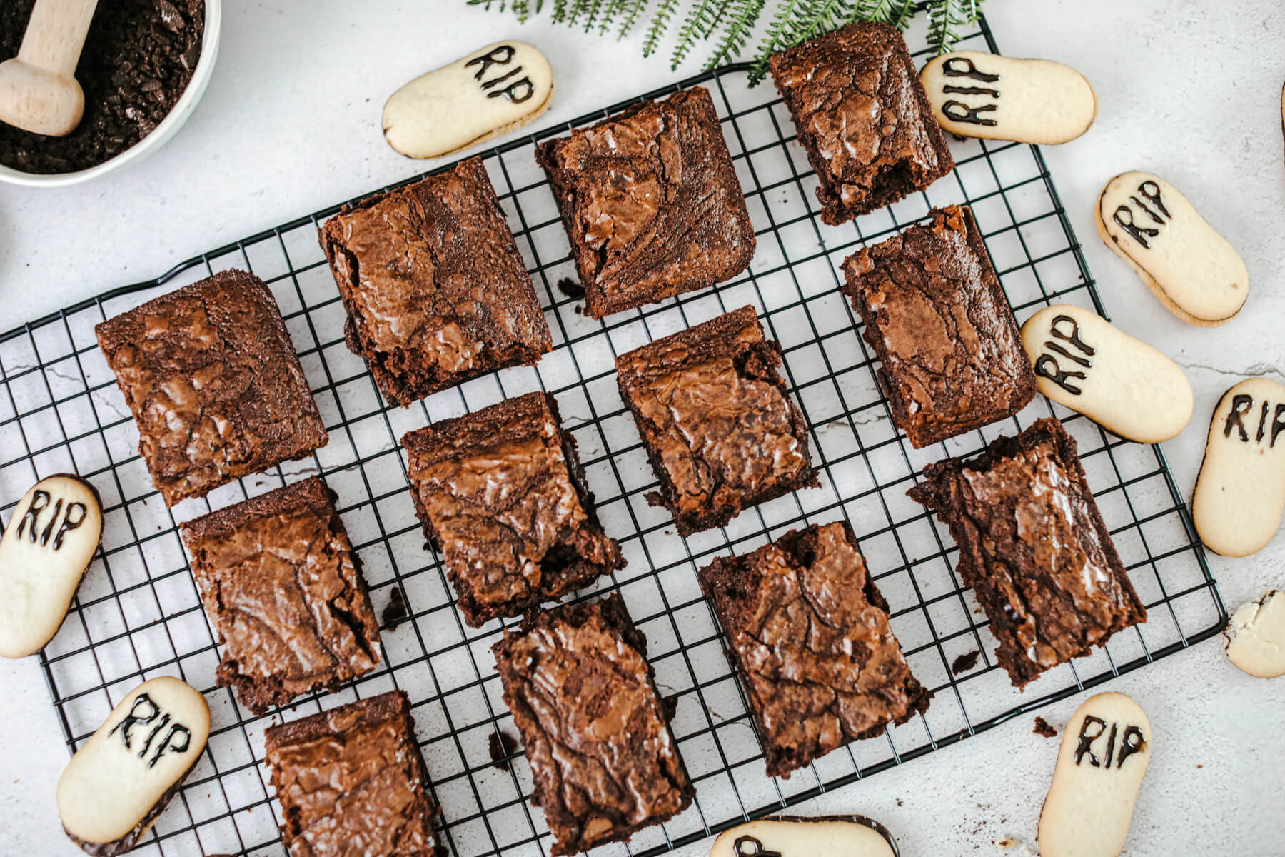 Twelve baked brownies on a wire cooling rack.