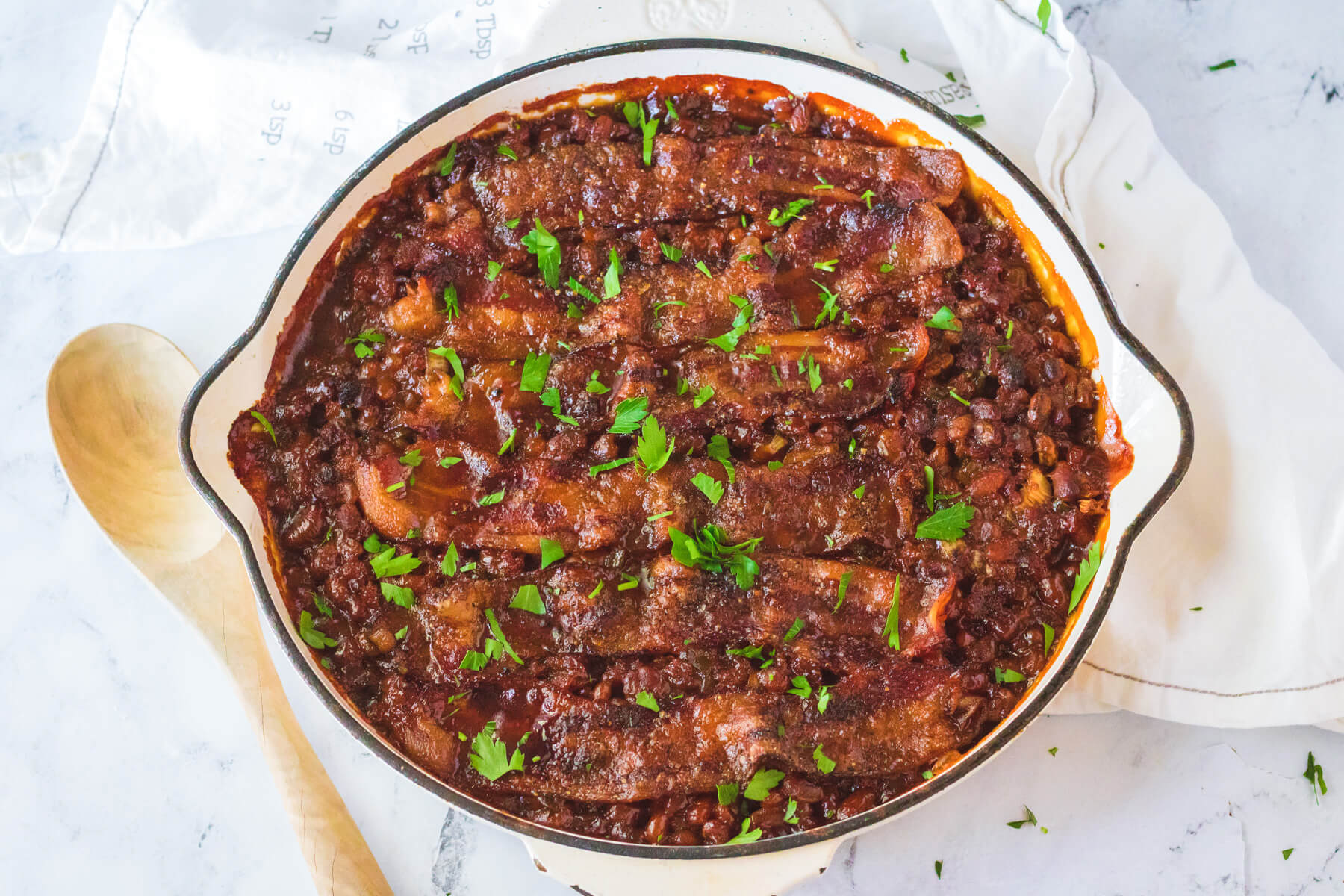 A skillet filled with Baked Beans with Ground Beef.