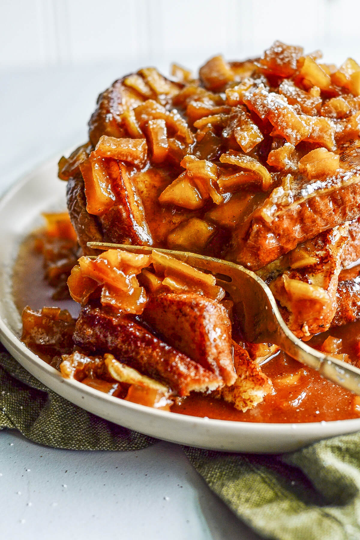 Cutting through a stack of Caramel Apple French toasts with a fork.