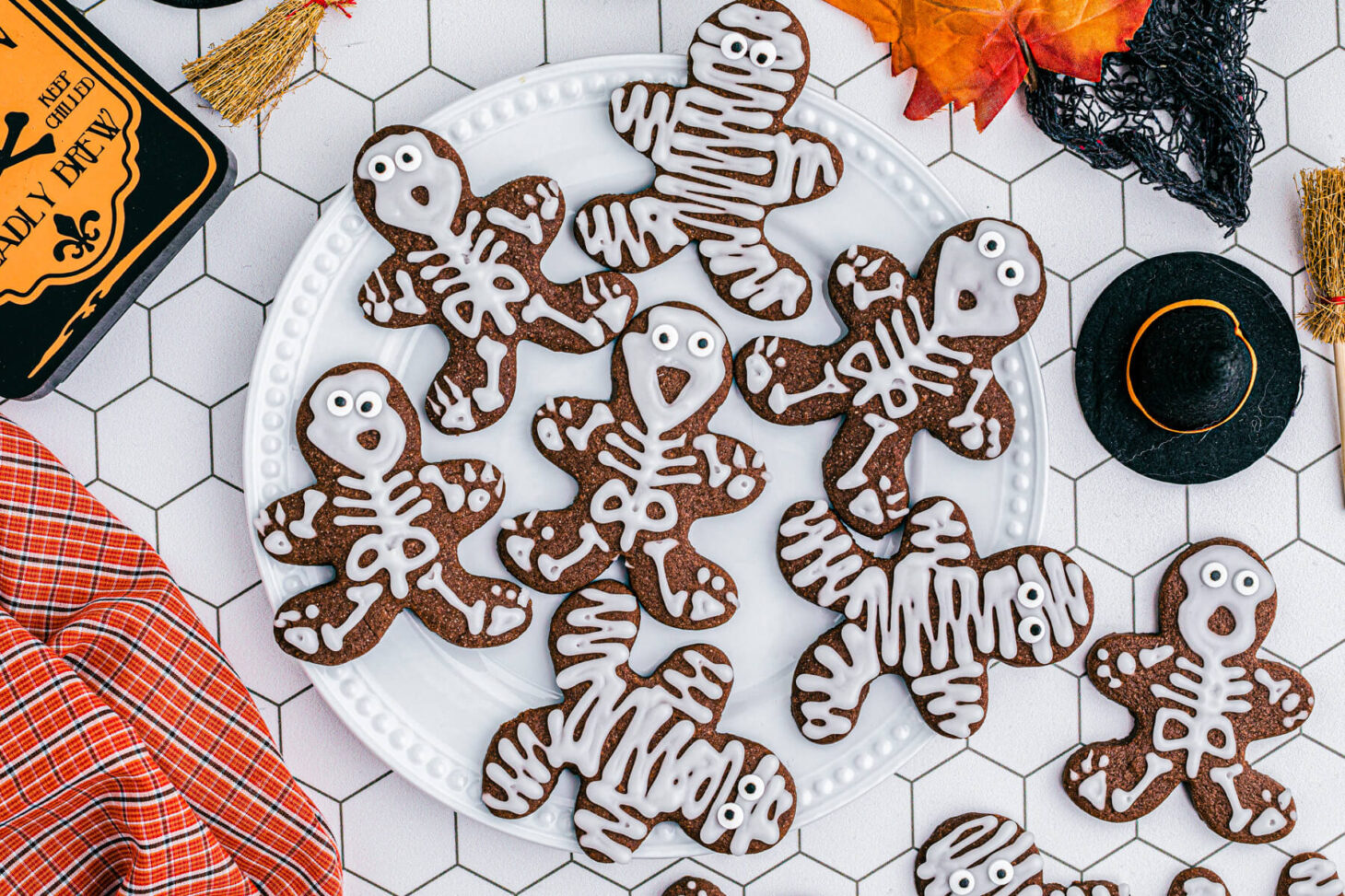 A plate of Chocolate Halloween Sugar Cookies decorated as mummies and skeletons.