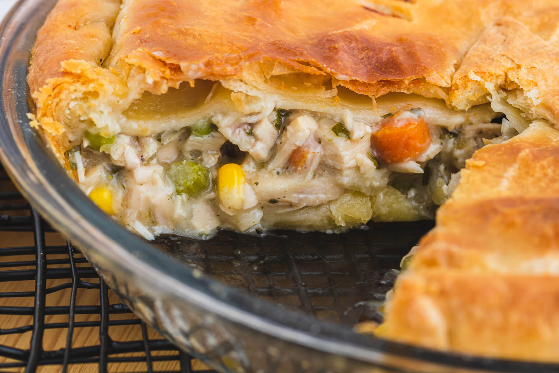 Close up of a golden baked turkey pie with a slice missing.