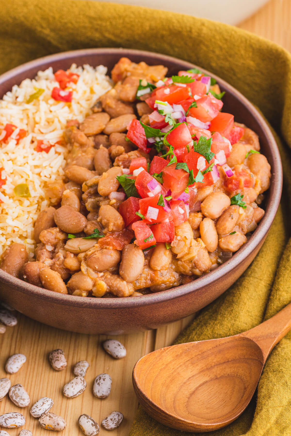 A bowl of creamy Pinto Beans and Rice topped with pico de gallo.