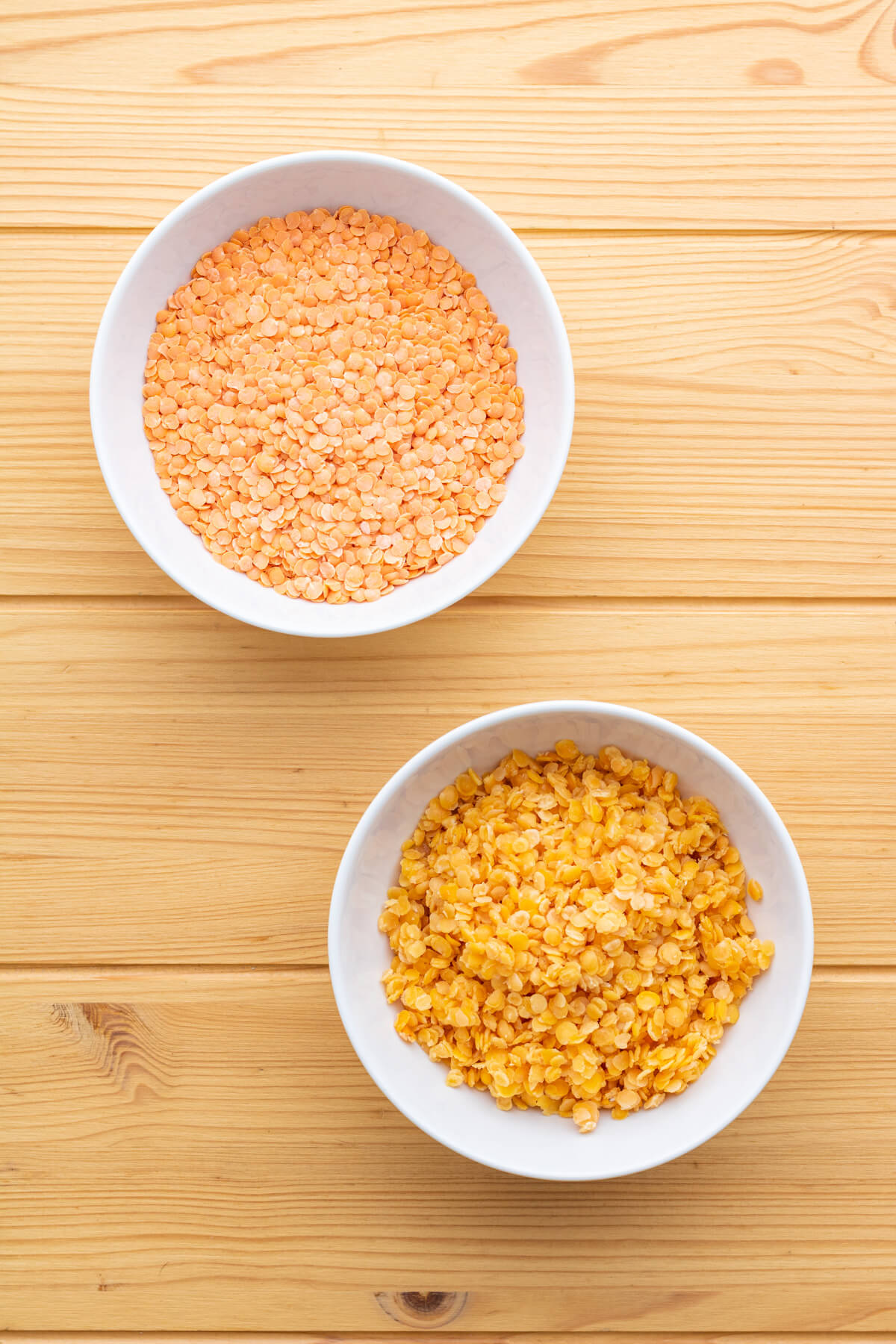 A comparison photo of two bowls of red lentils. One bowl contains raw lentils, the other contains cooked red lentils.