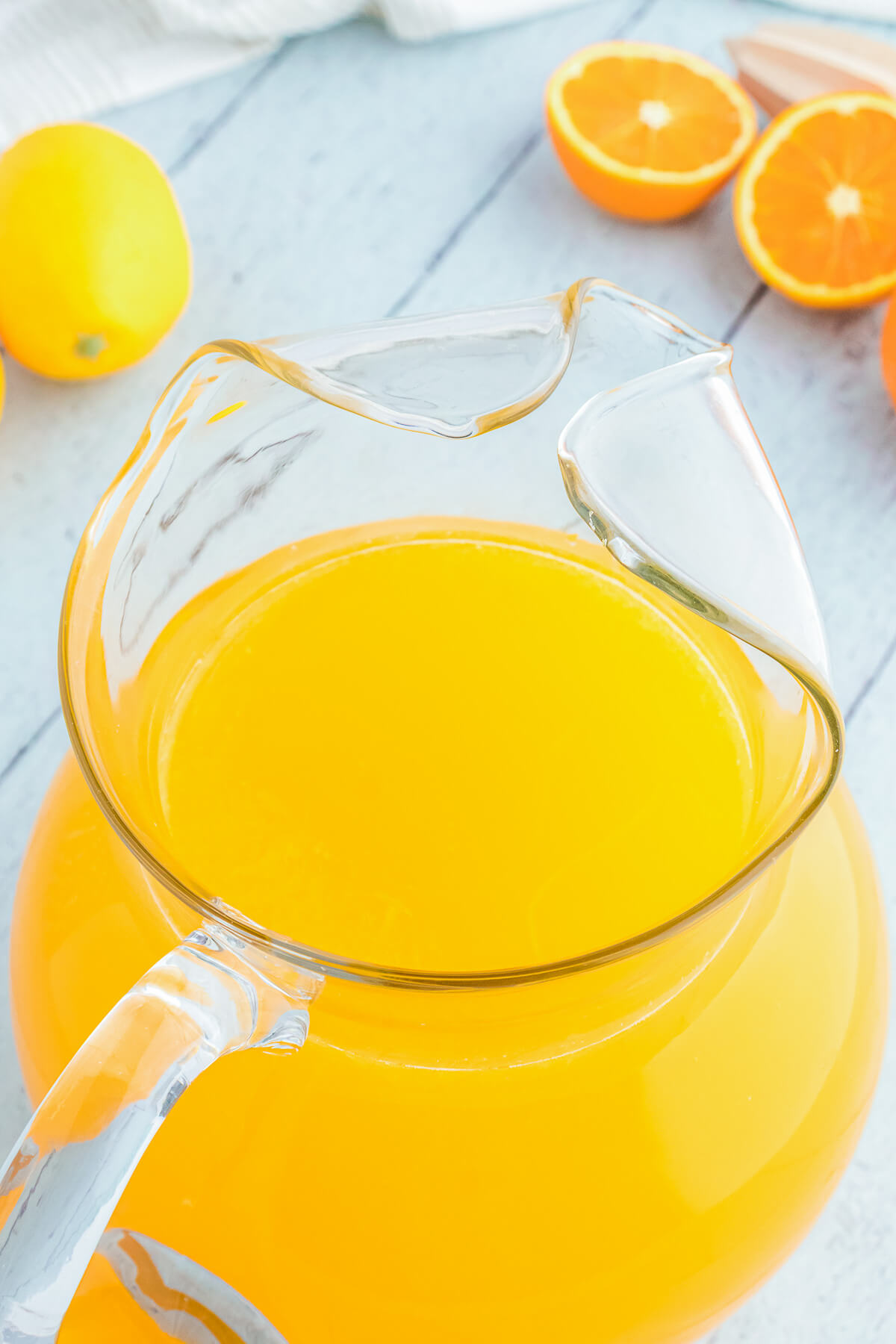 A glass pitcher filled with vibrant homemade orangeade.