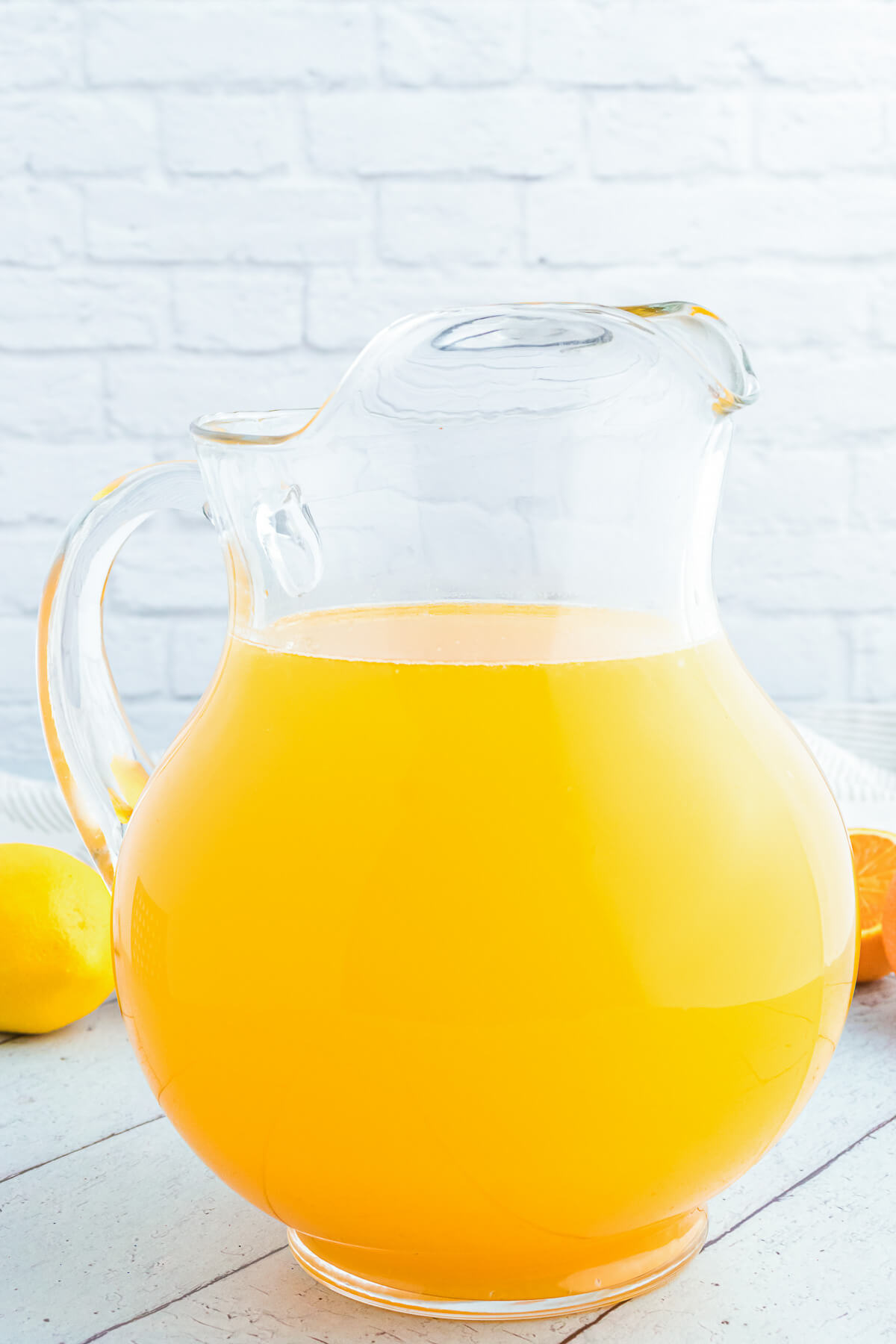 A glass pitcher filled with vibrant homemade orangeade.