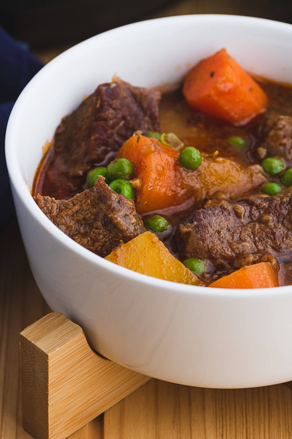 Close up image of rich and chunky Instant pot beef stew in a white bowl. 