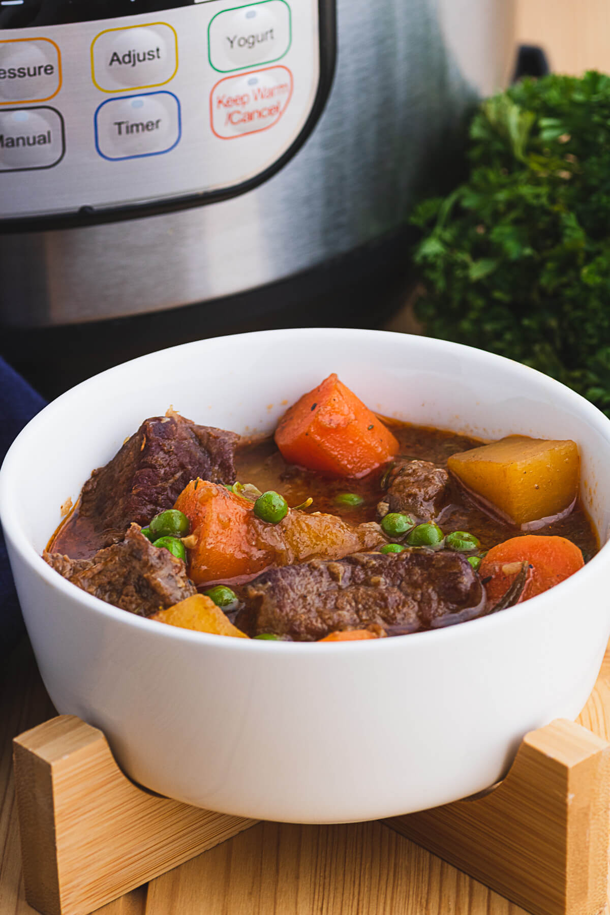 Rich and chunky Instant pot beef stew in a white bowl.