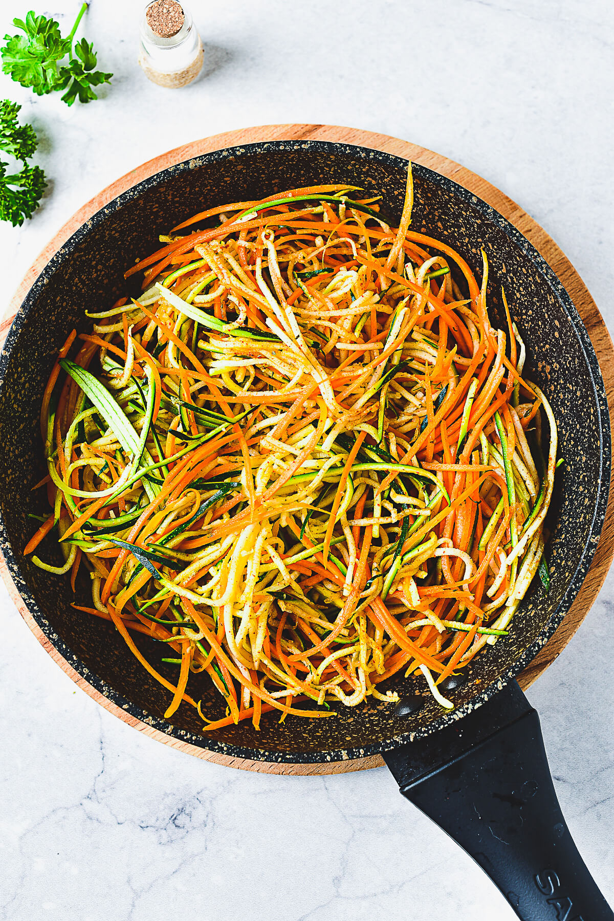 A saute pan full of spiralized vegetables.