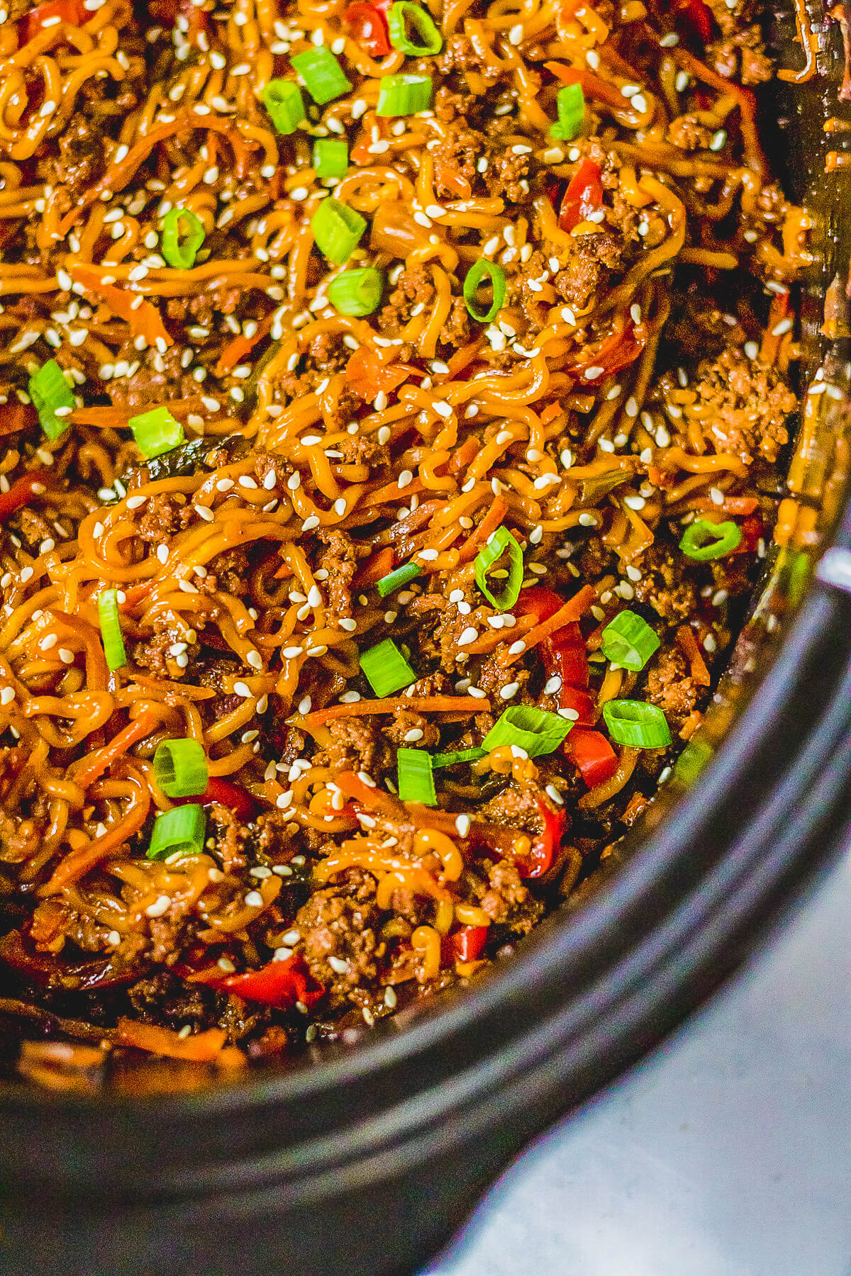 Saucy Beef Ramen Noodles and vegetables in a black slow cooker.