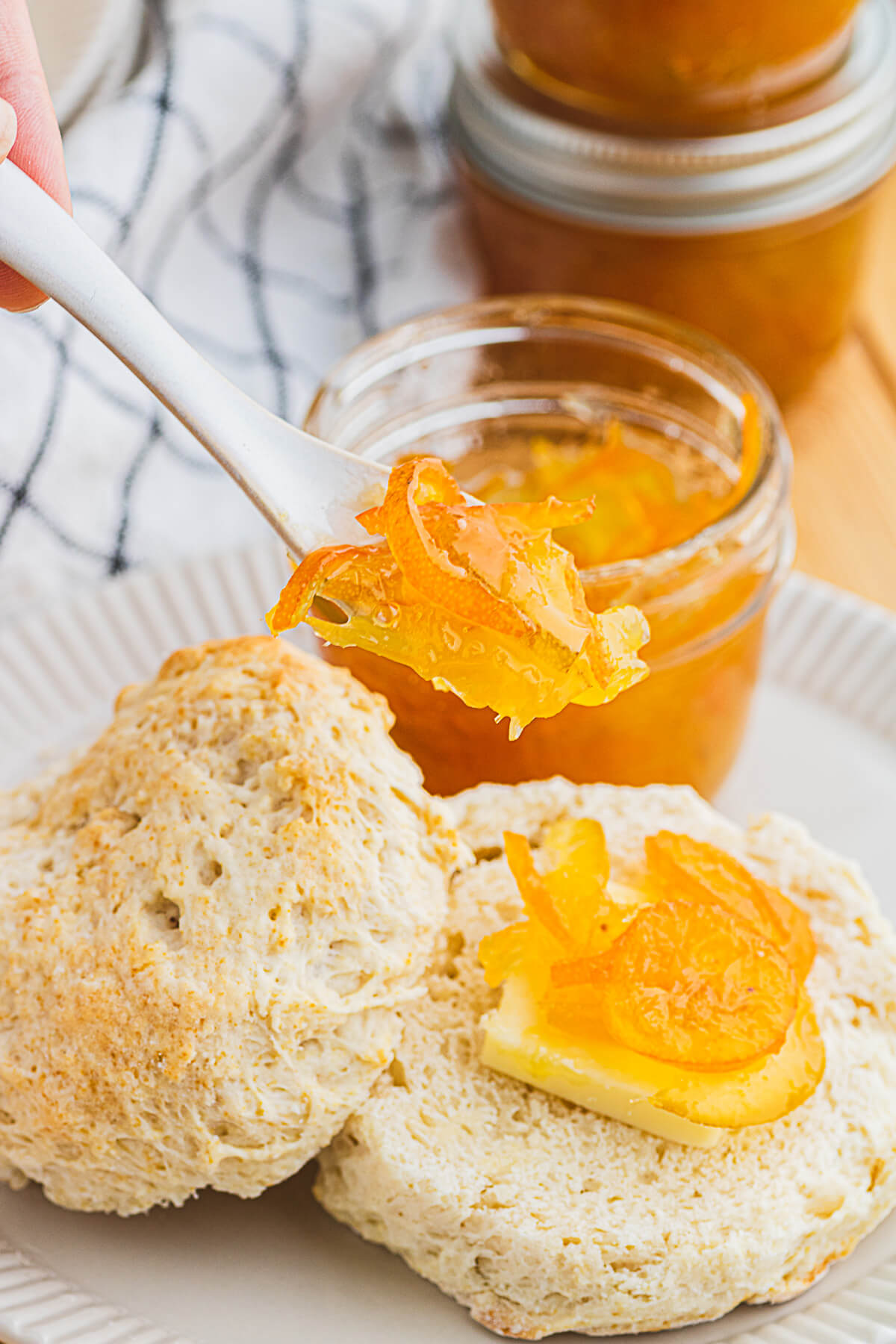A small spoon of Kumquat Marmalade over a biscuit topped with more marmalade.