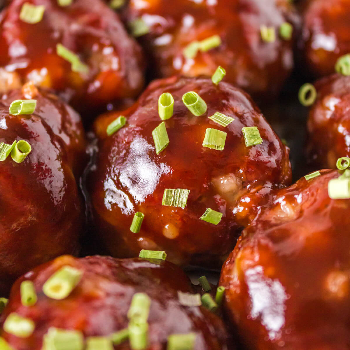 A white bowl of Smoked Meatballs glazed in BBQ Sauce.