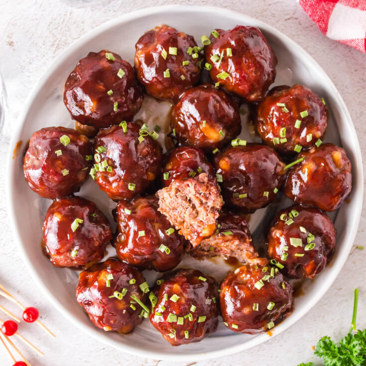 A white bowl of Smoked Meatballs glazed in BBQ Sauce.