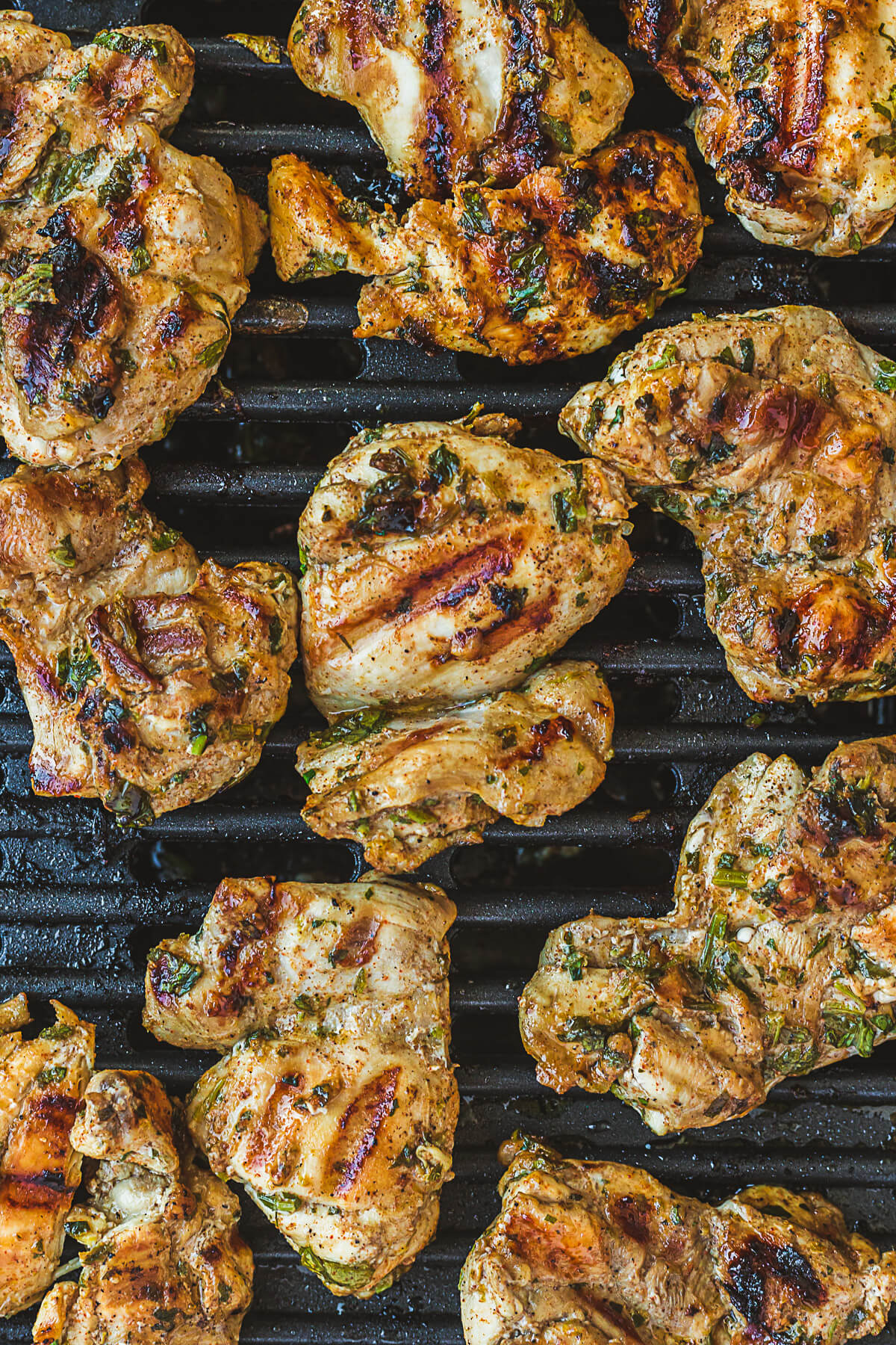 Chicken thighs being grilled on a barbecue.