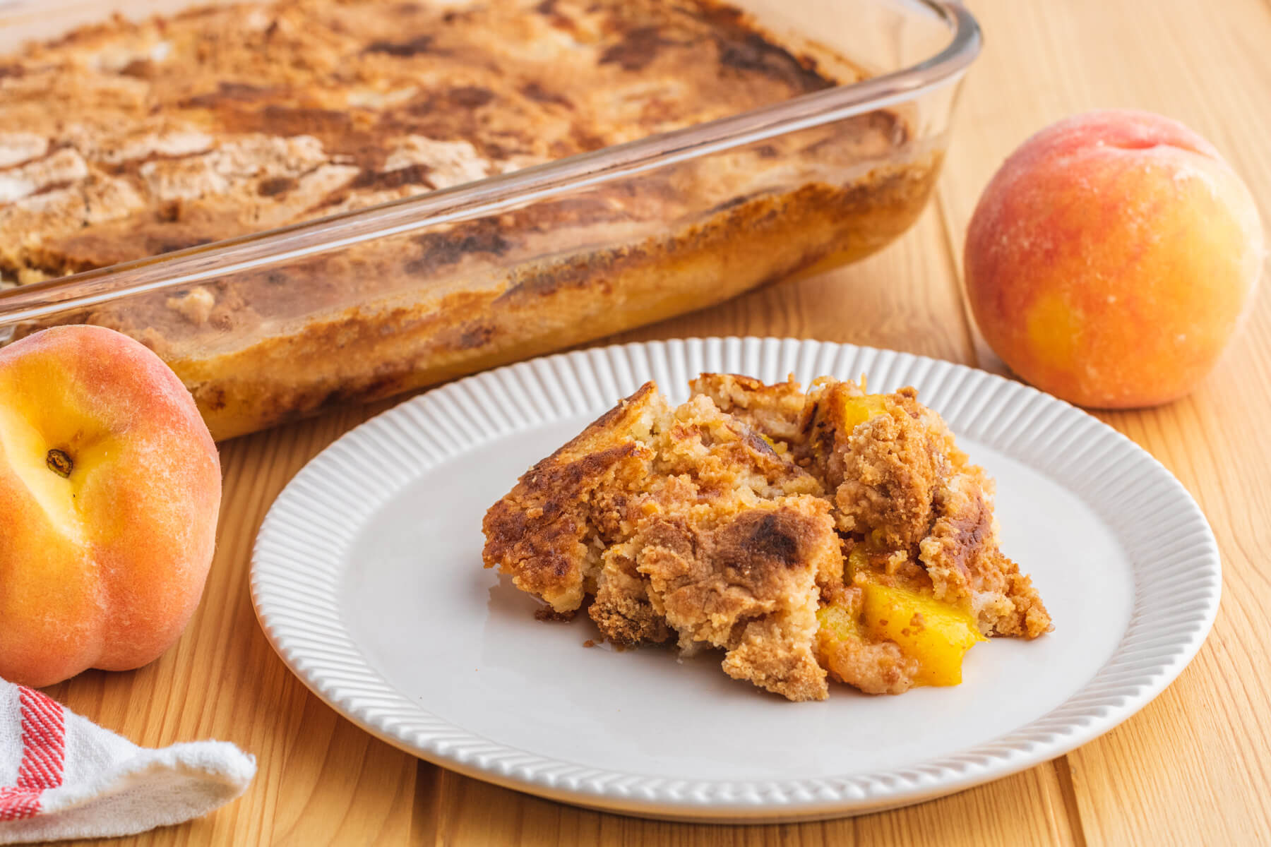 A white plate containing a scoop of peach cobbler dump cake.