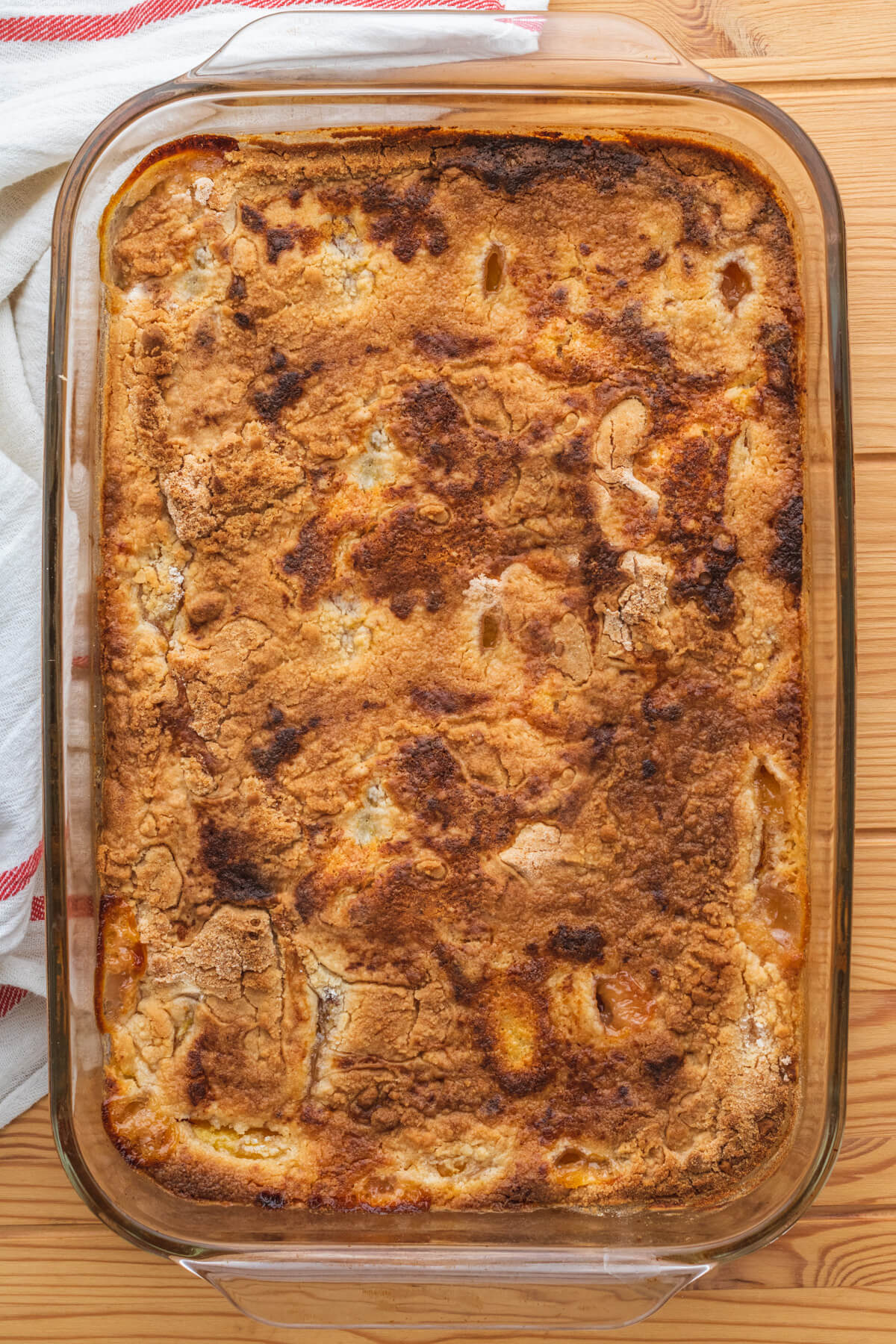 A glass baking dish filled with Peach Cobbler Dump Cake.