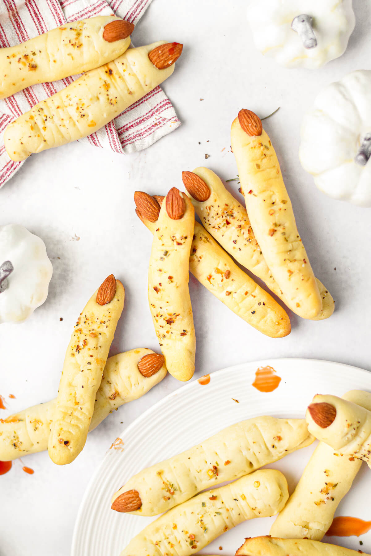 A pile of Italian breadsticks shaped like witch's fingers on a white table.