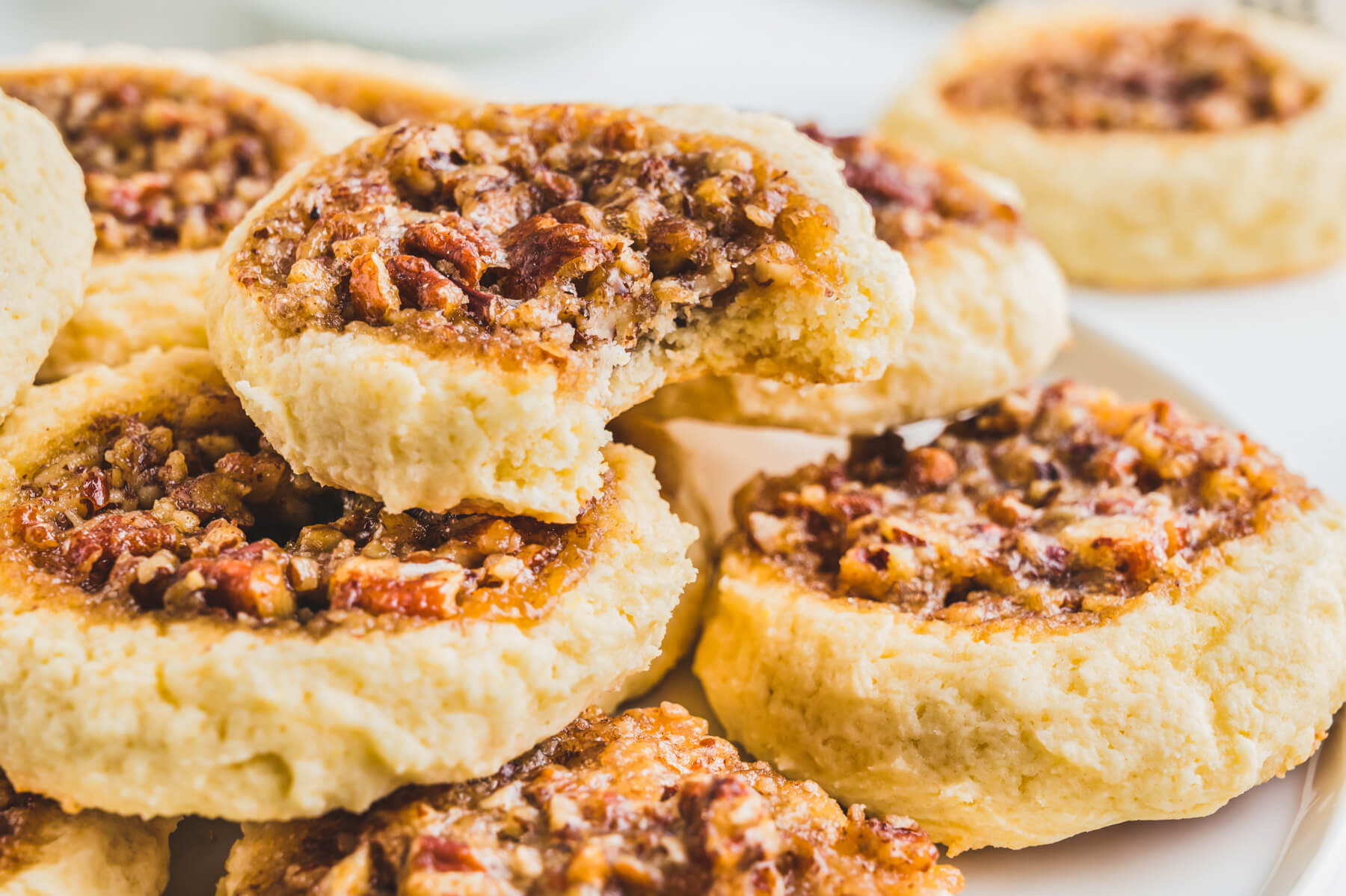 A pile of pecan pie cookies on a white plate.