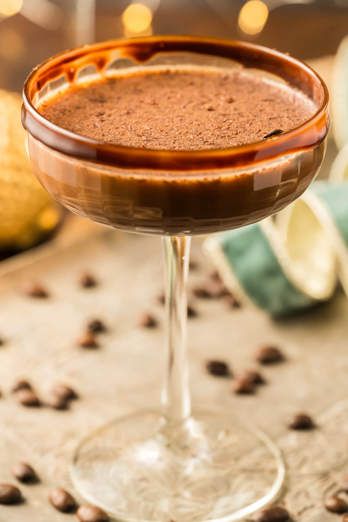 One creamy brown Chocolate Espresso Martini in a coupe cocktail glass garnished with chocolate rim and chocolate shavings.