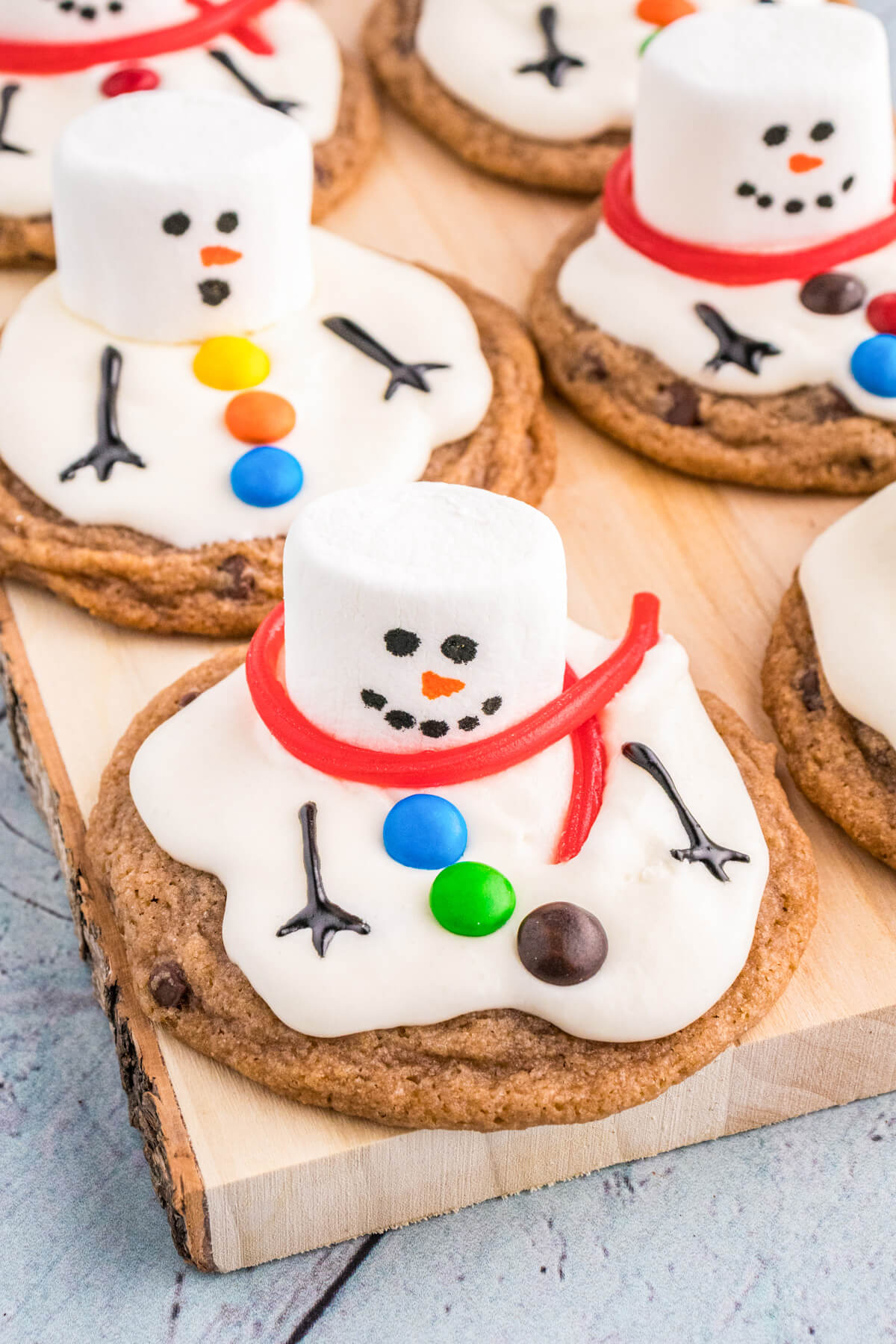A group of Melted Snowman cookies on a wooden board.