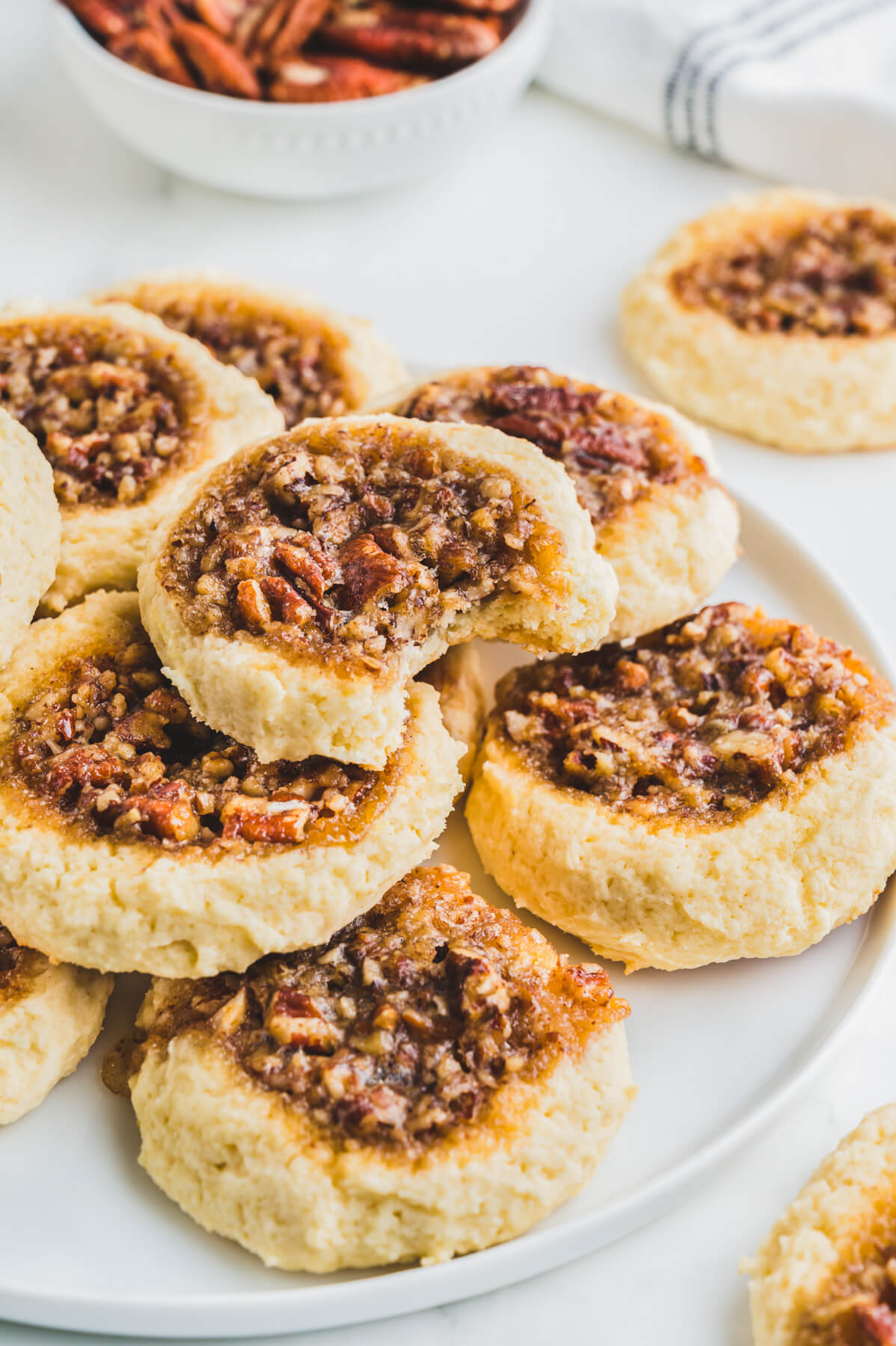 A pile of pecan pie cookies on a white plate.