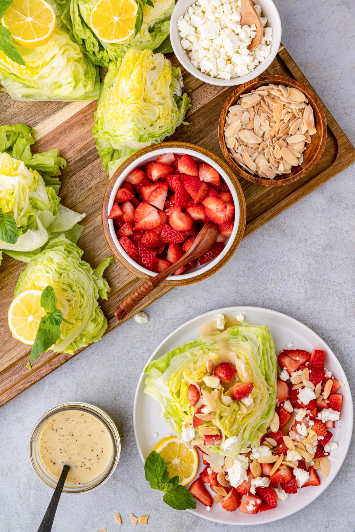 A Strawberry Feta Wedge Salad on white plate in front of a salad serving board.