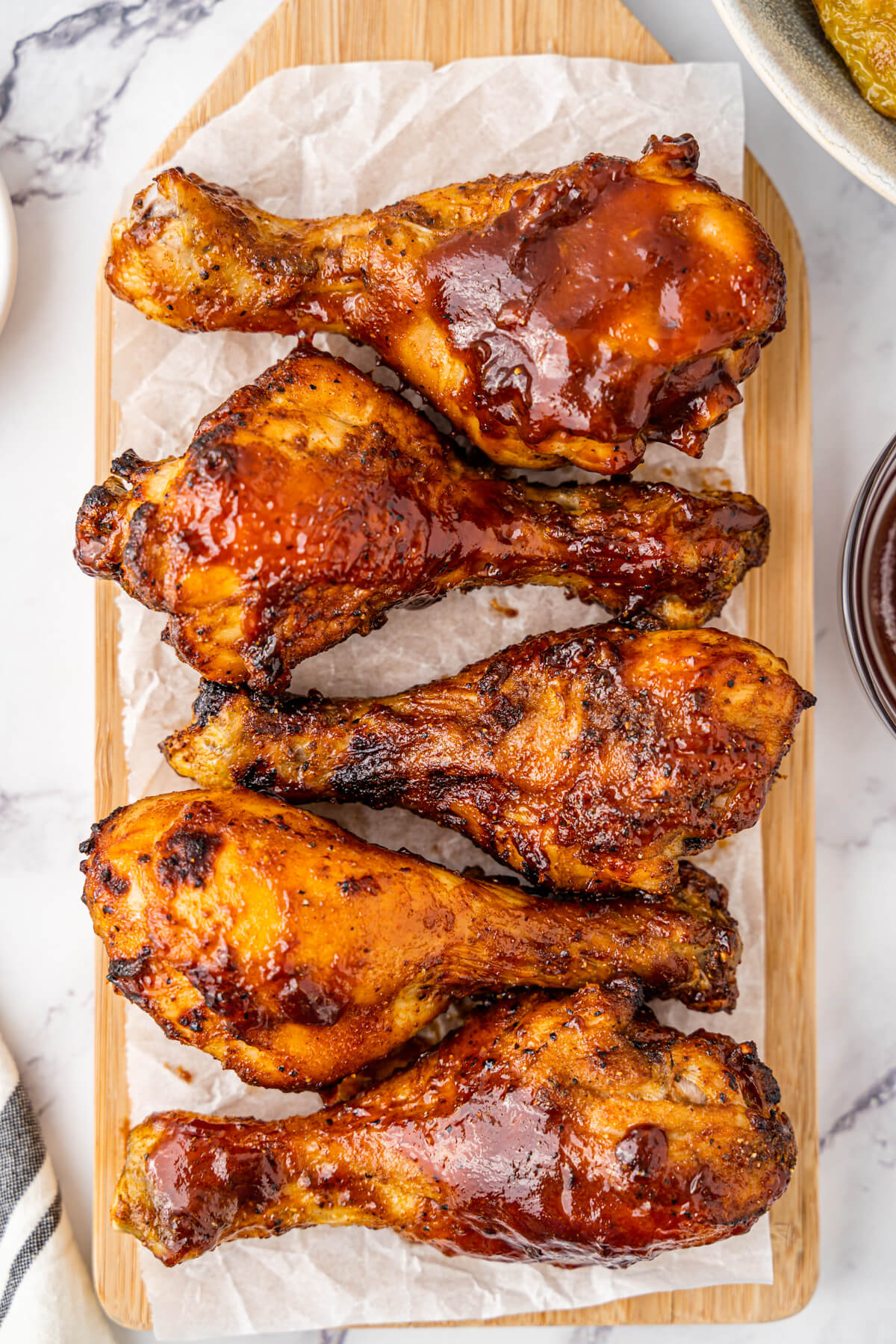 Crispy cooked chicken drumsticks coated in barbecue sauce on a platter.