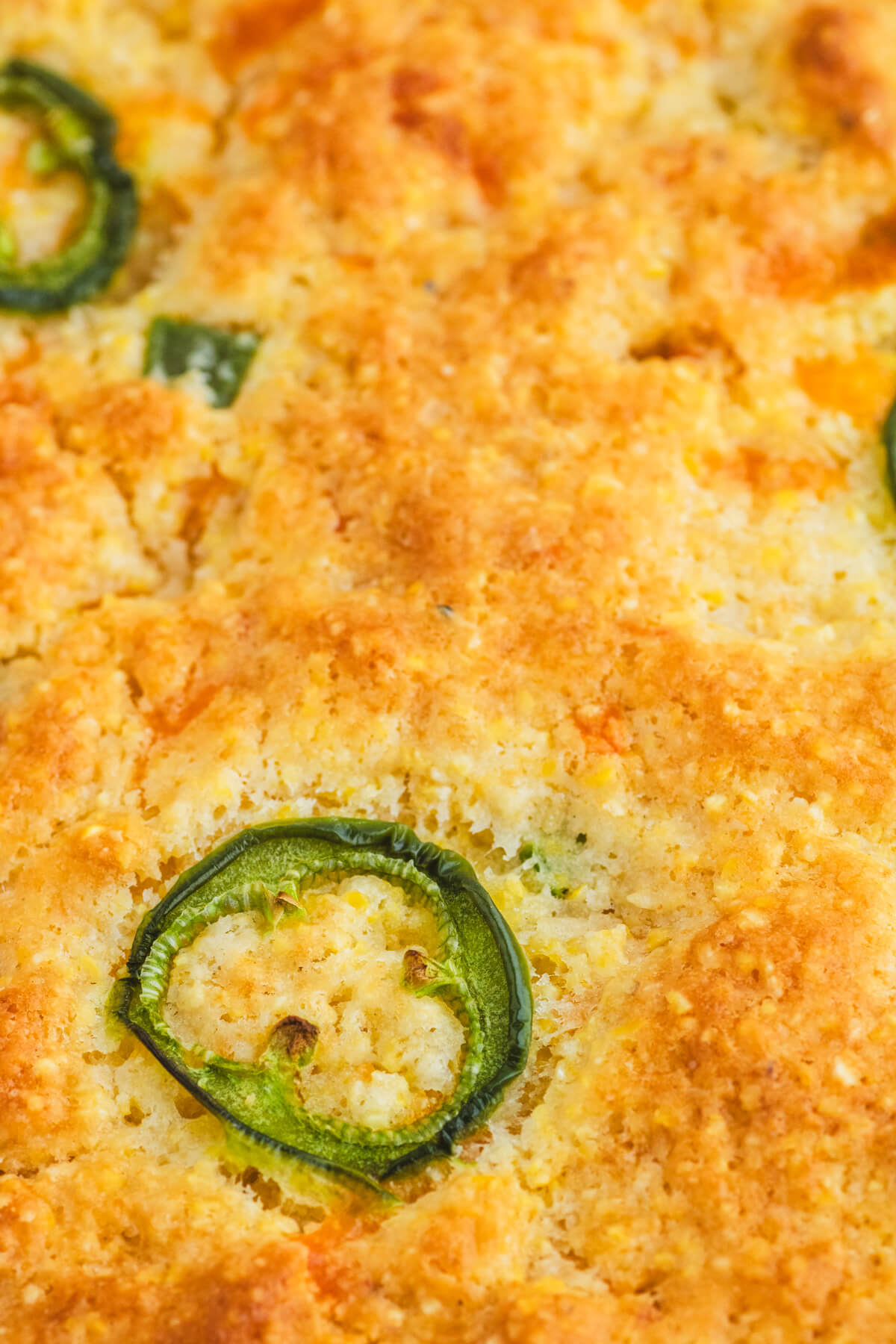 Close up crispy edge of golden baked Jalapeno cheddar cornbread.