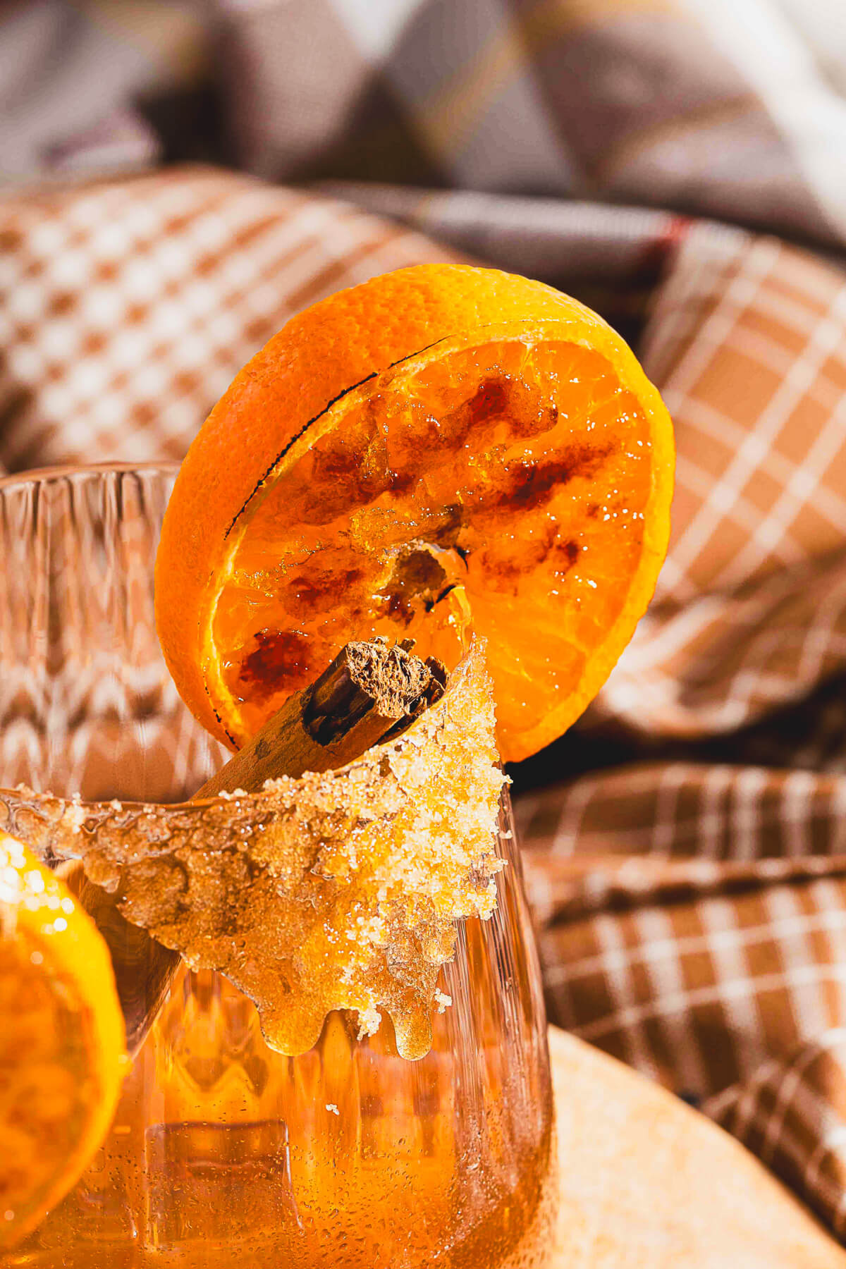 Close up of a bruleed orange garnish on a cocktail glass.