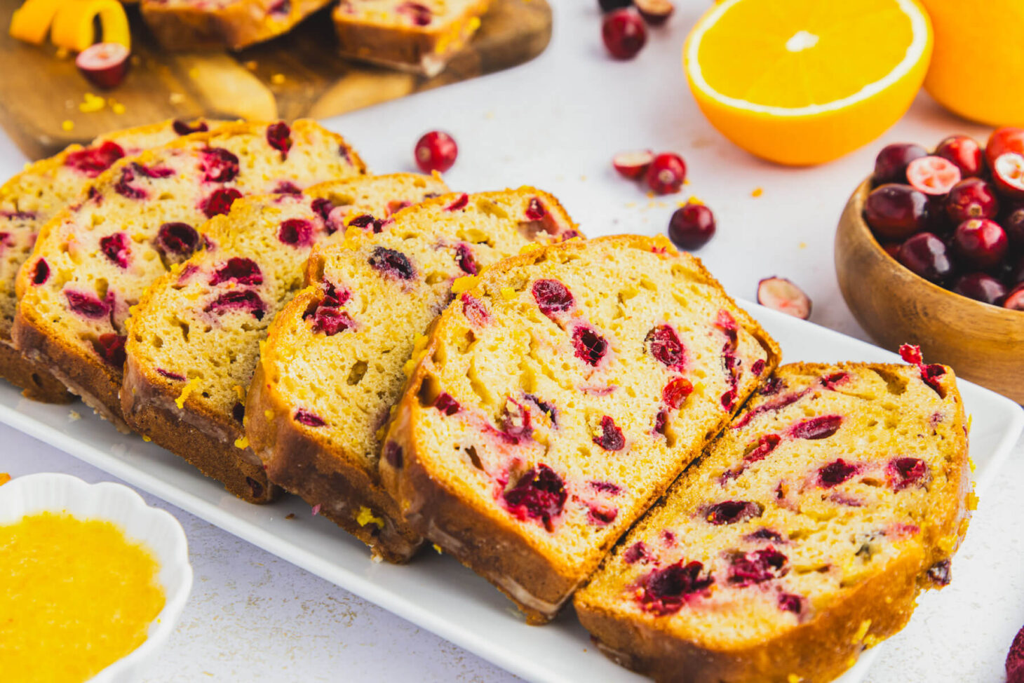 A white tray containing slices of Orange Cranberry Loaf showing the vibrant red cranberries.