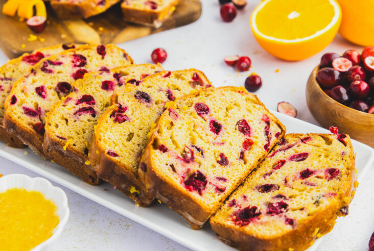 A white tray containing slices of Orange Cranberry Loaf showing the vibrant red cranberries.