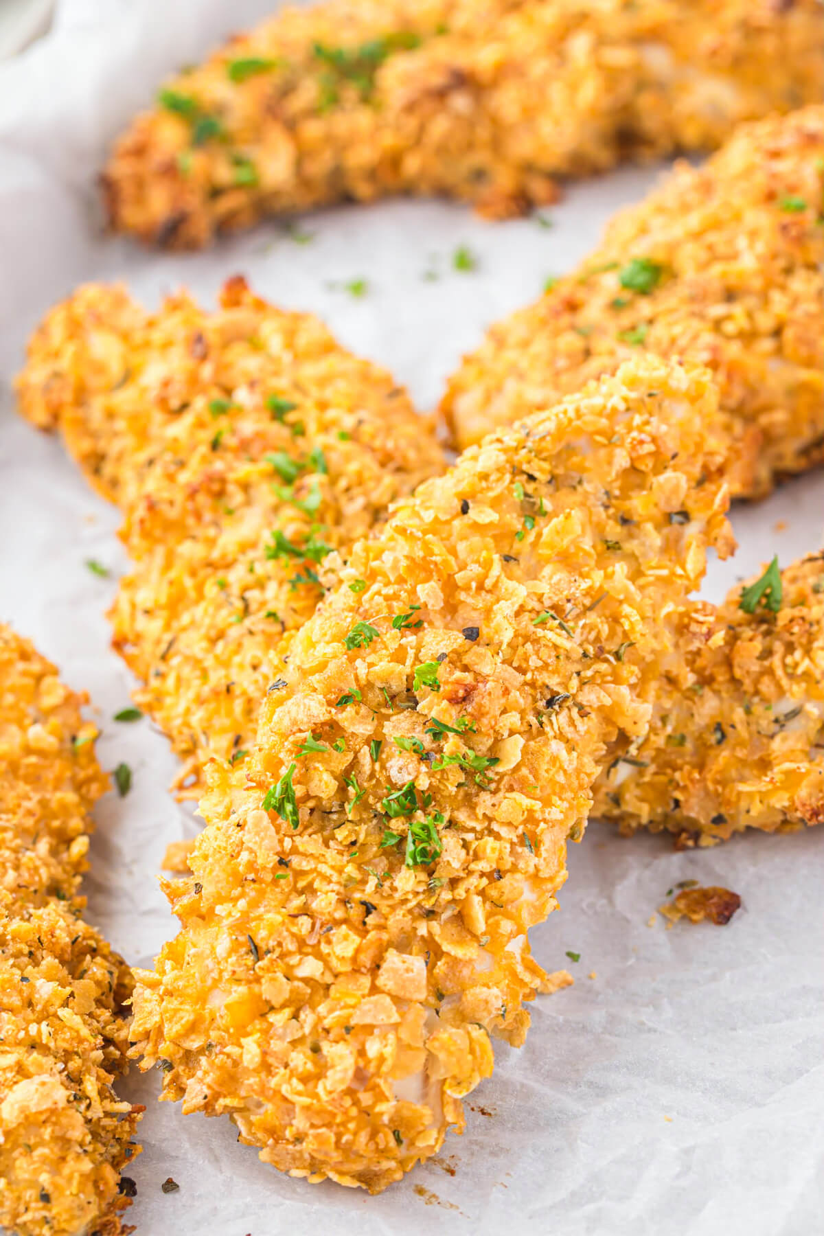 Golden baked Cornflake Chicken Tenders on a white serving platter.