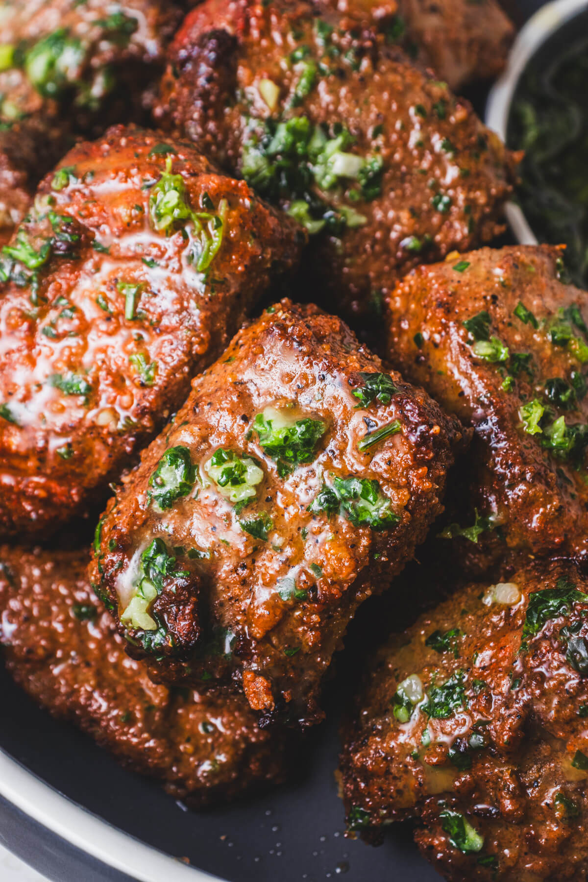 Close up photo of perfectly seared steak bites covered in garlic parsley butter sauce.